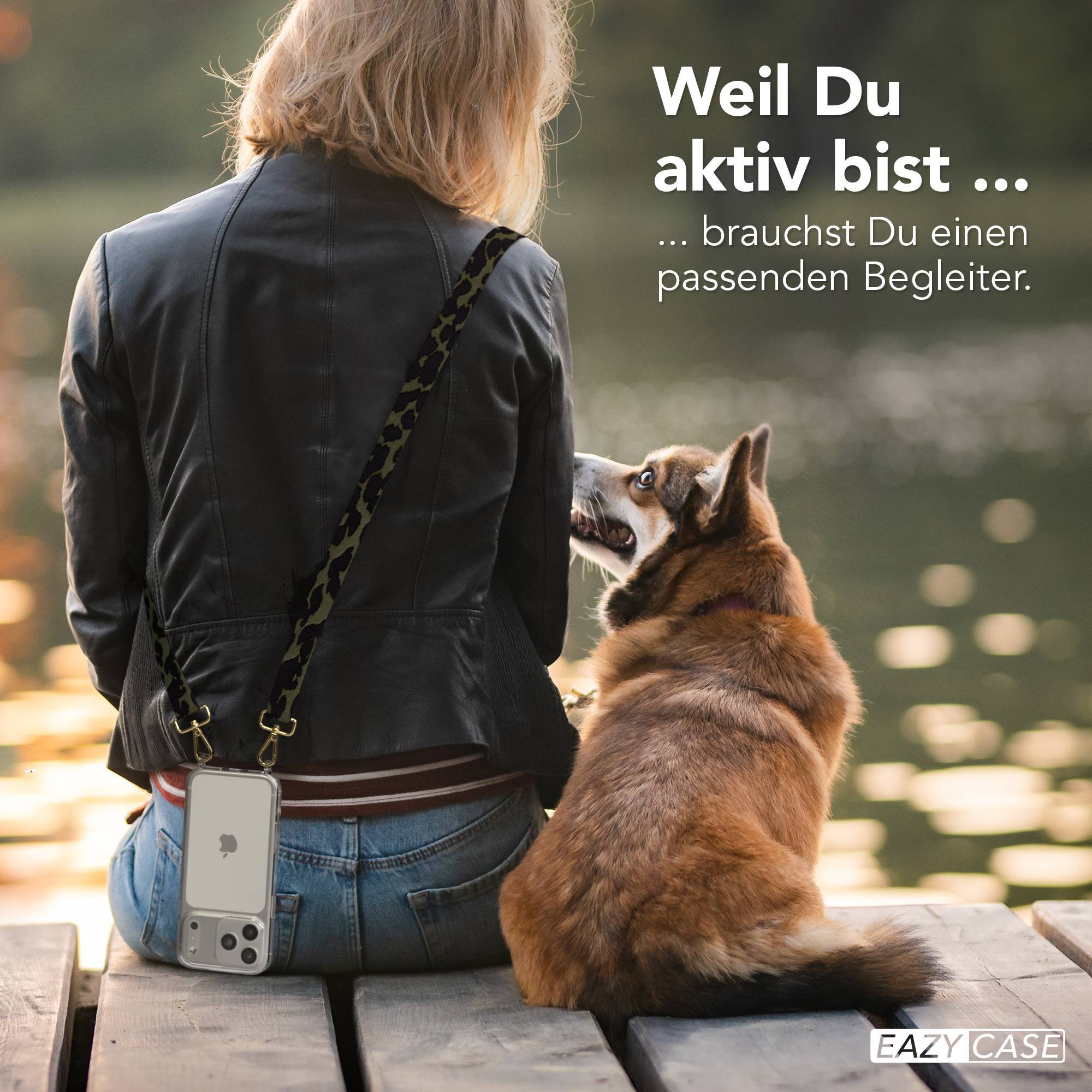 Frau mit Hund sitzt auf Holzsteg, Handy mit Tragegurt.