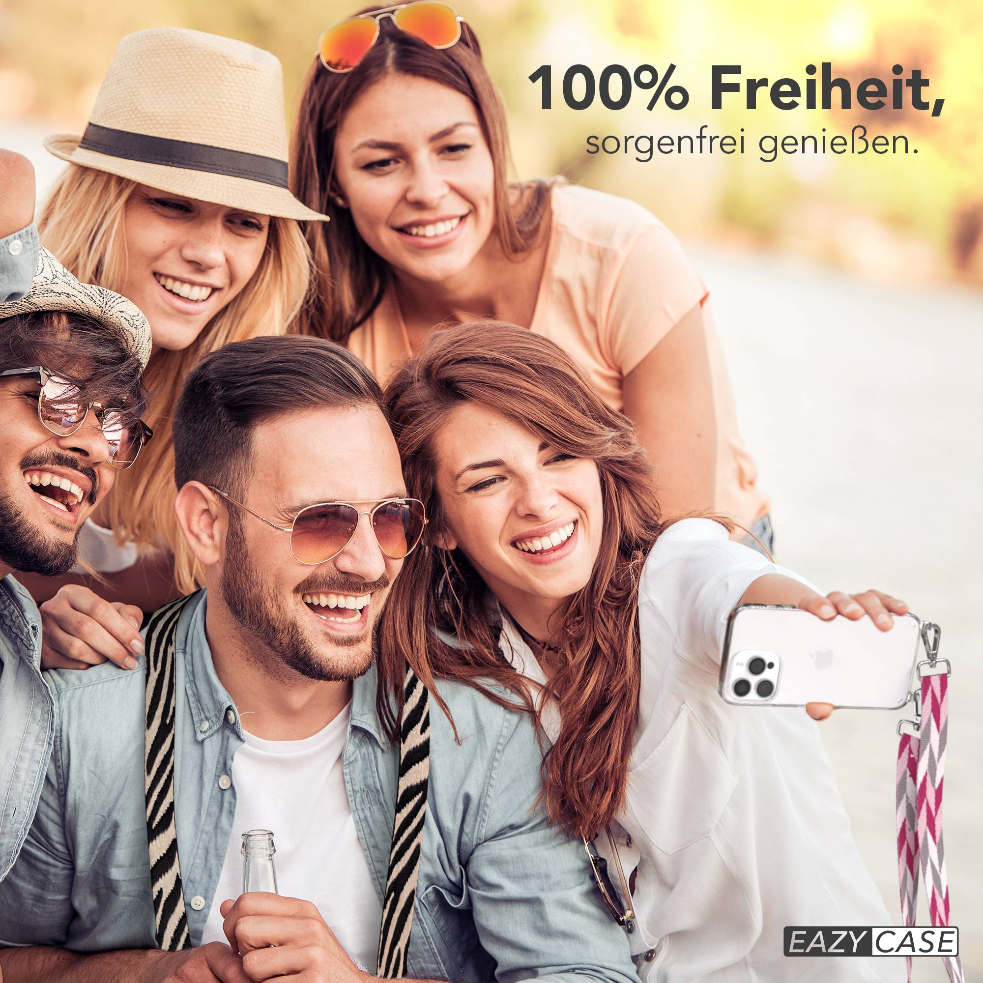 Vier lachende Freunde machen ein Selfie mit einem Handy, das eine bunte Handschlaufe hat.