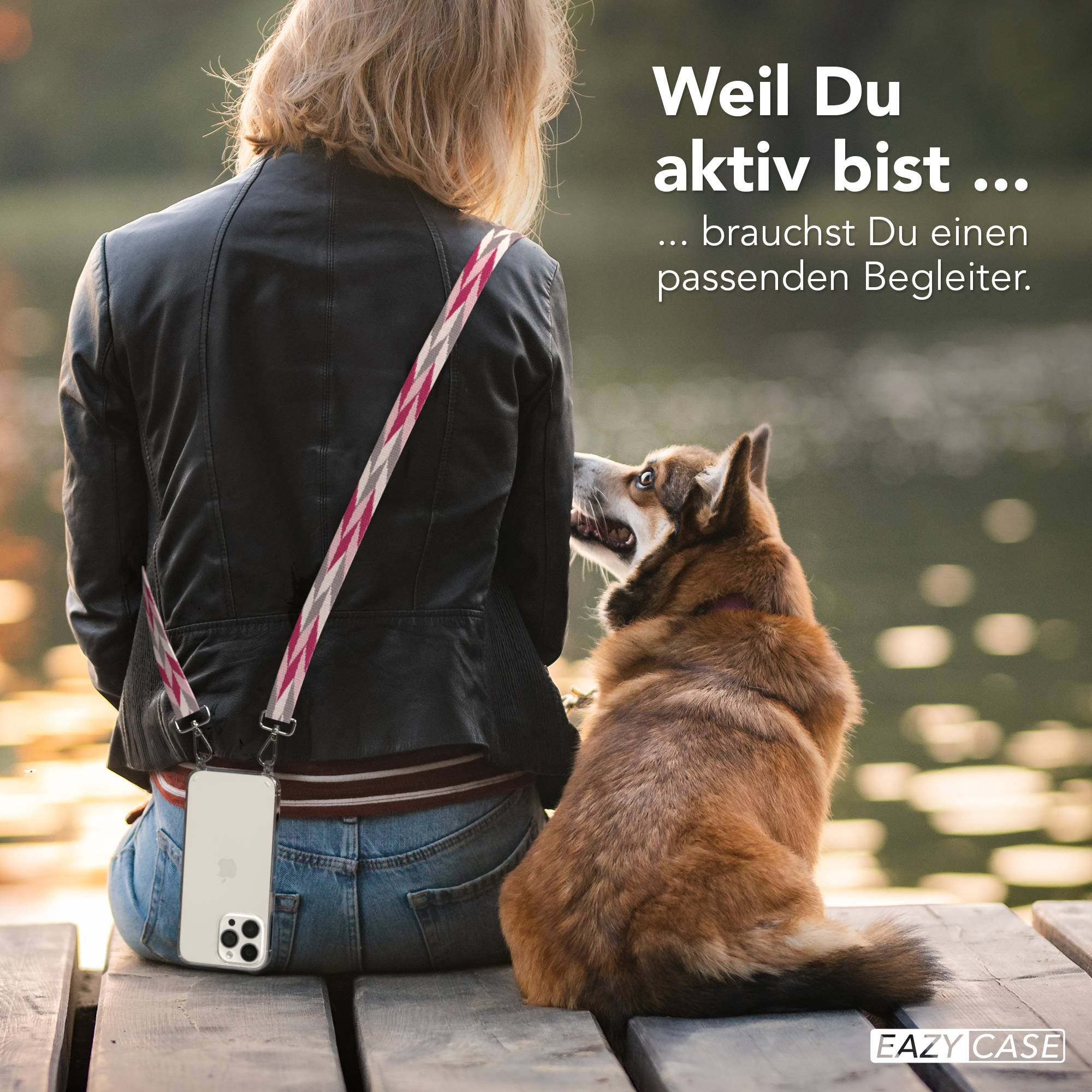 Frau mit Hund sitzt auf Holzsteg, Handy am Gurt.