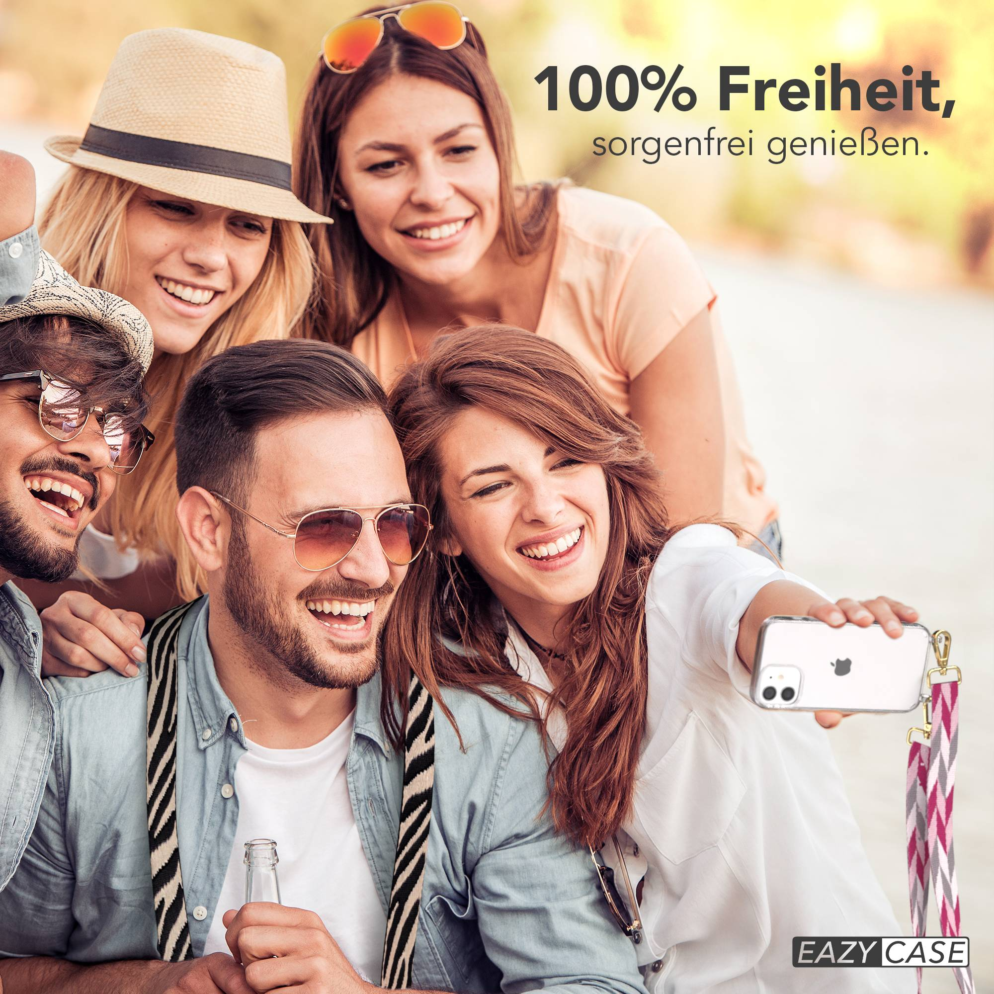 Vier Freunde machen draußen ein Selfie, sie lächeln und lachen. Einer hält ein Handy.