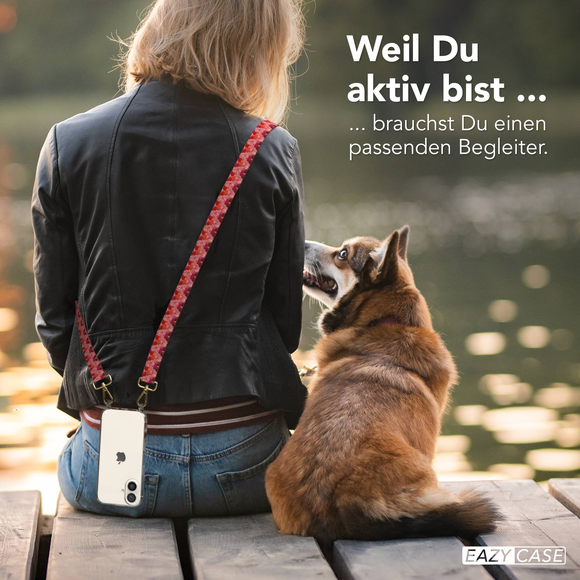 Frau mit Hund sitzt auf Holzsteg, Handy über Schulter.