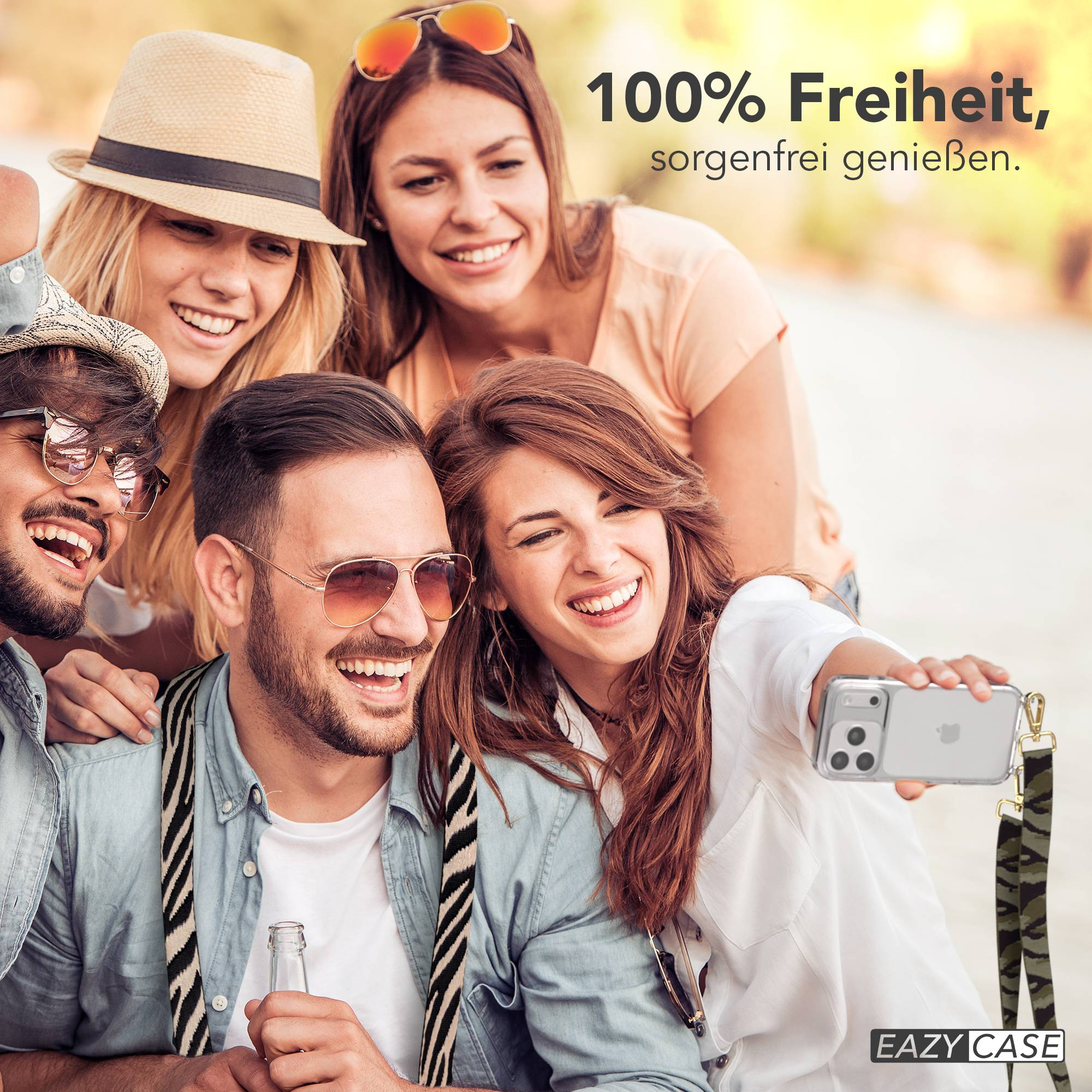 Vier lachende Freunde machen ein Selfie im Freien. Eine Frau hält das Handy.