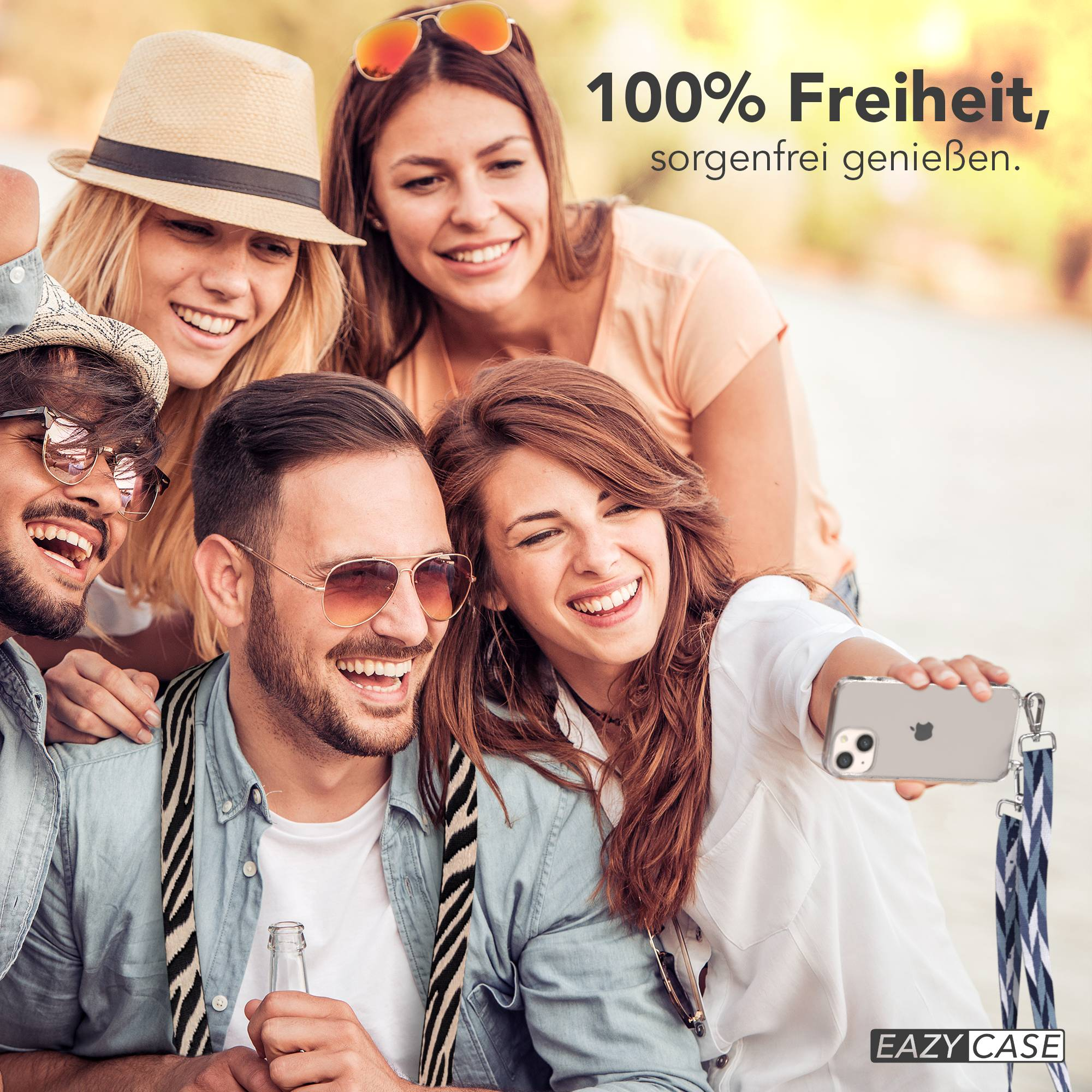 Vier lachende Freunde machen ein Selfie im Freien. Ein Mann hält eine Flasche.