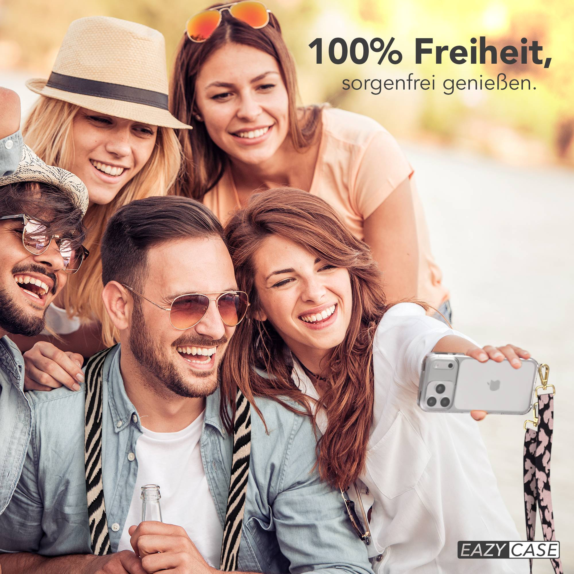 Freunde machen draußen ein Selfie mit einem Handy, lächelnd und lachend.