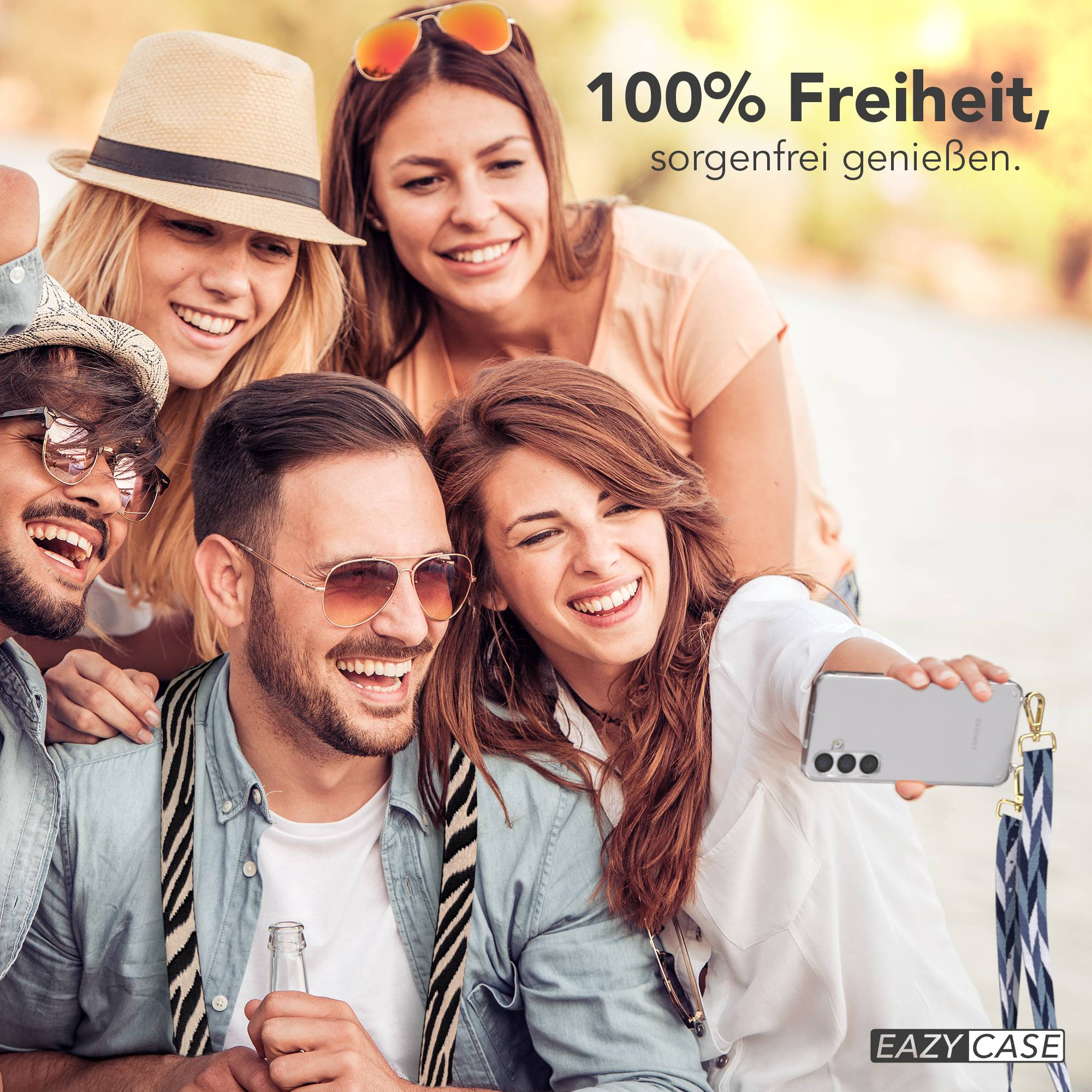 Vier Freunde machen ein Selfie im Freien, eine Frau hält ein Handy mit einer Handyhülle.
