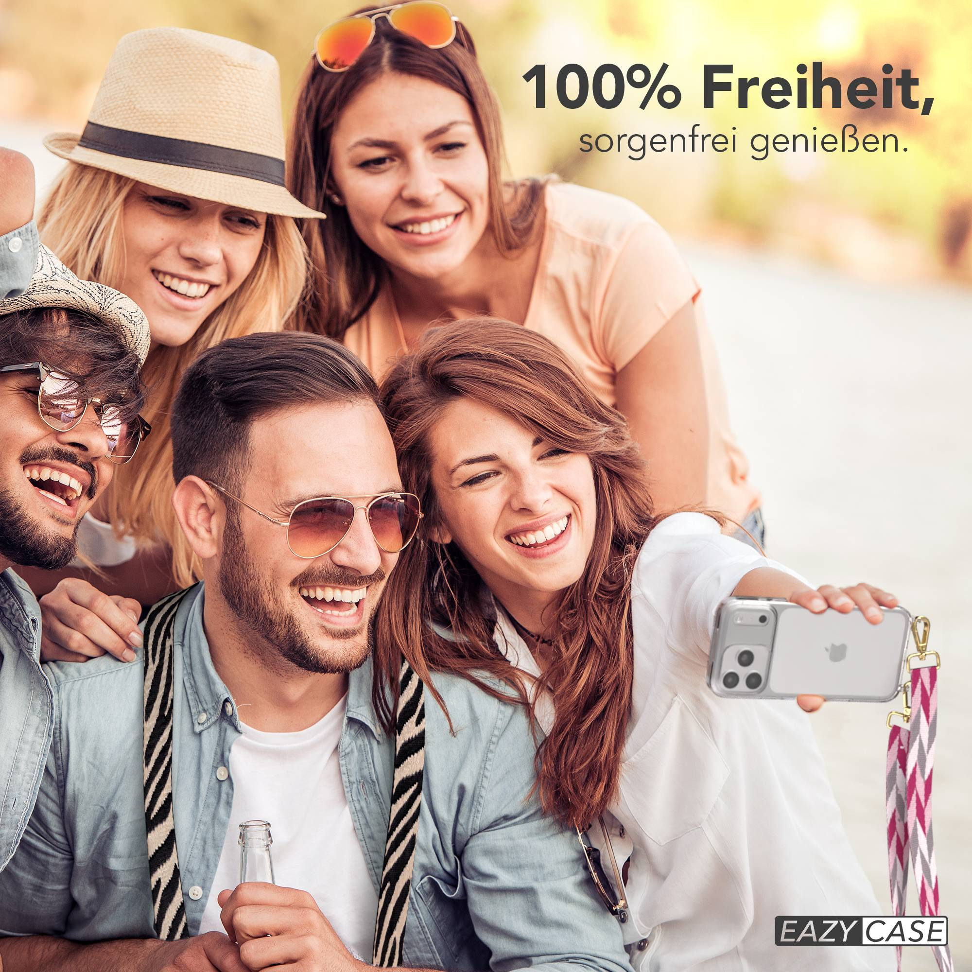 Vier Freunde machen draußen ein Selfie und lächeln. Einer hält ein Handy und eine Flasche.