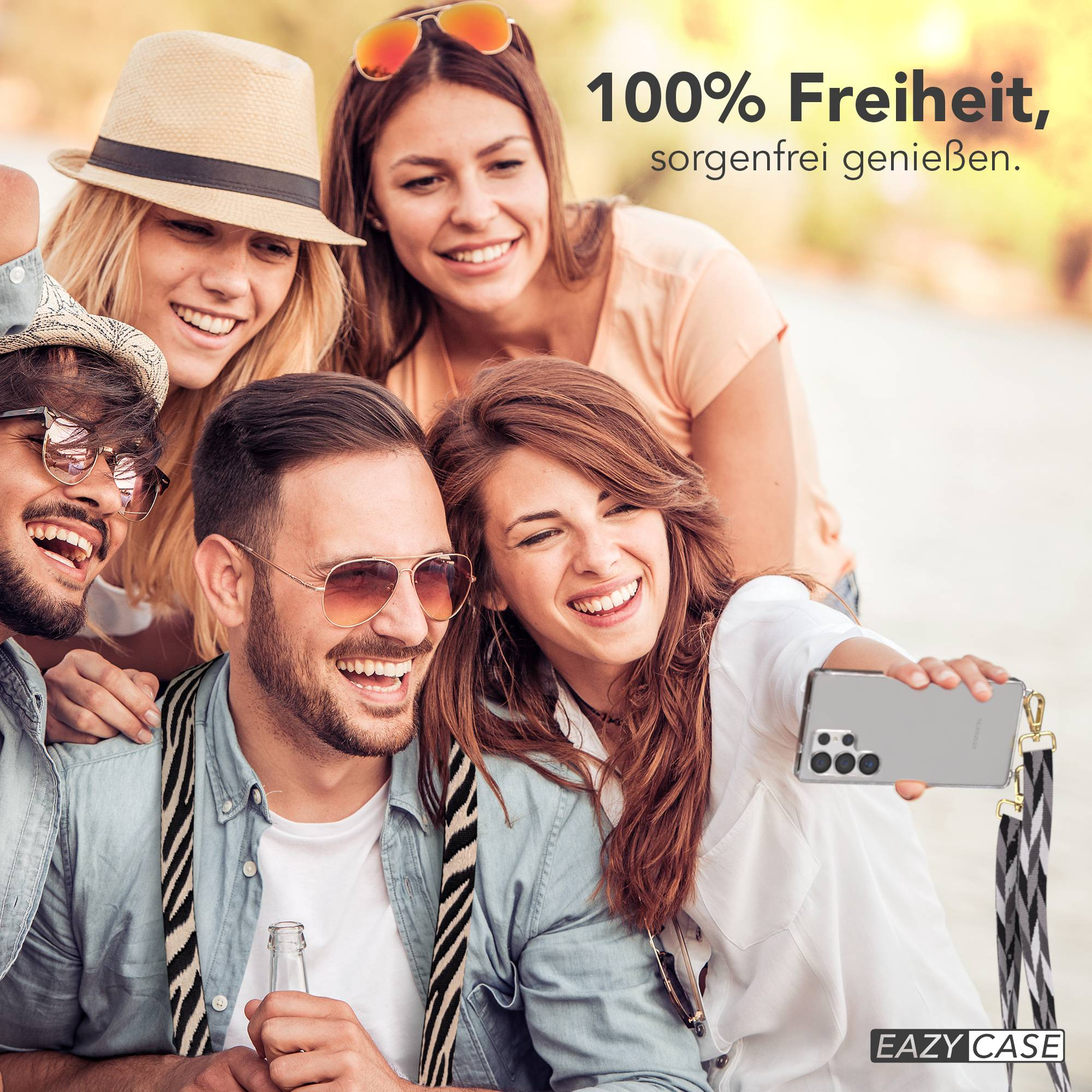 Vier Freunde machen draußen ein Selfie. Einer hält ein Handy, ein anderer eine Flasche.