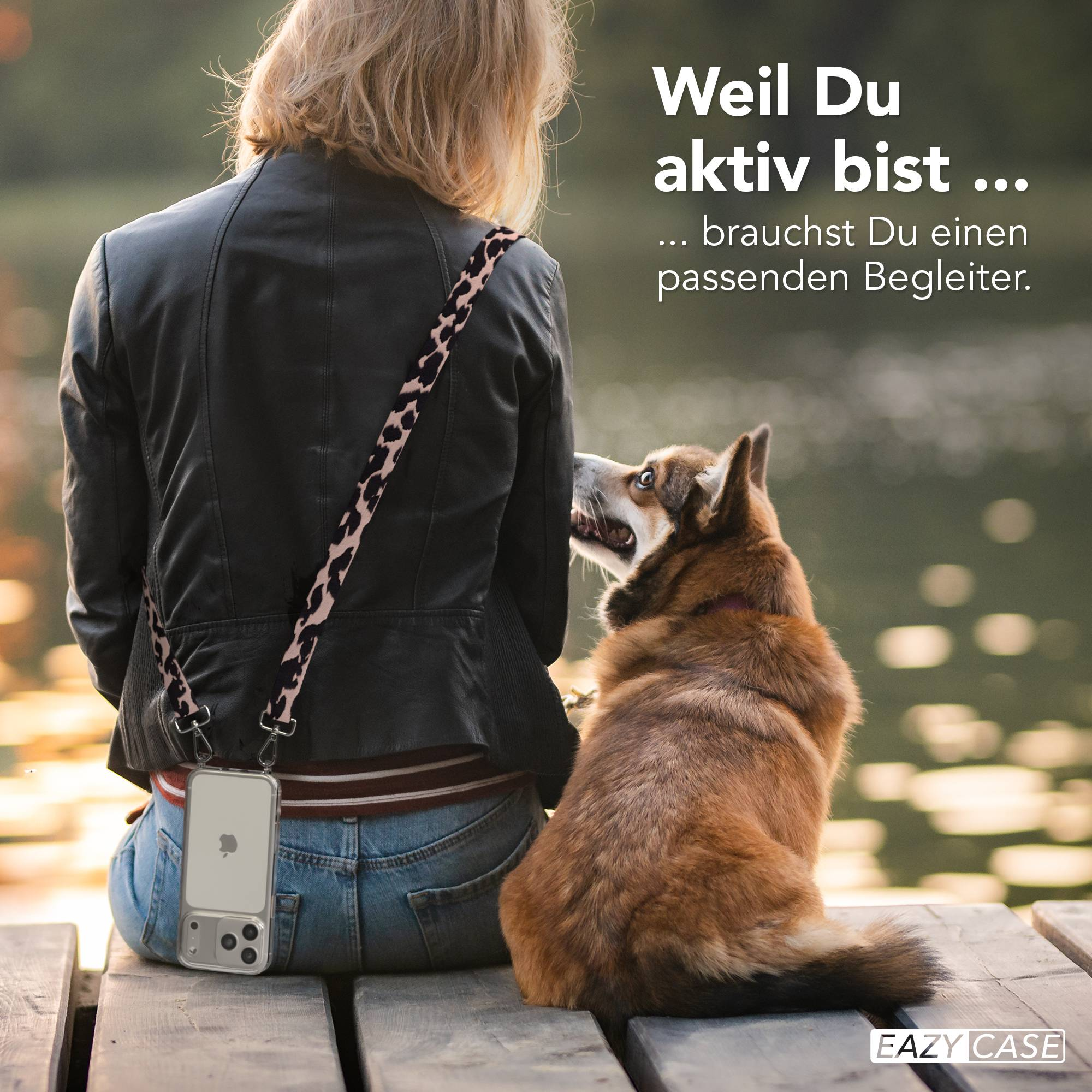 Frau mit Hund sitzt auf Holzsteg. iPhone am Trageriemen. Wasser im Hintergrund.
