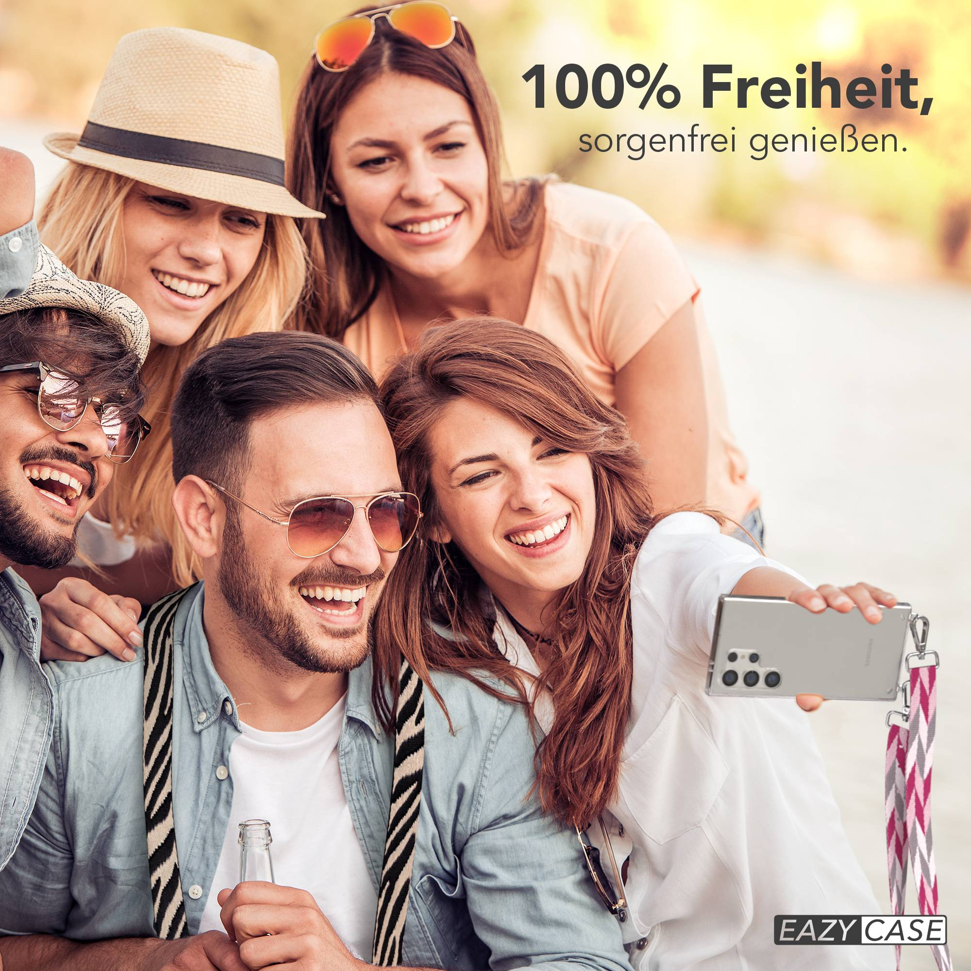 Vier lachende Freunde machen ein Selfie mit einem Handy. Einer hält eine Flasche.