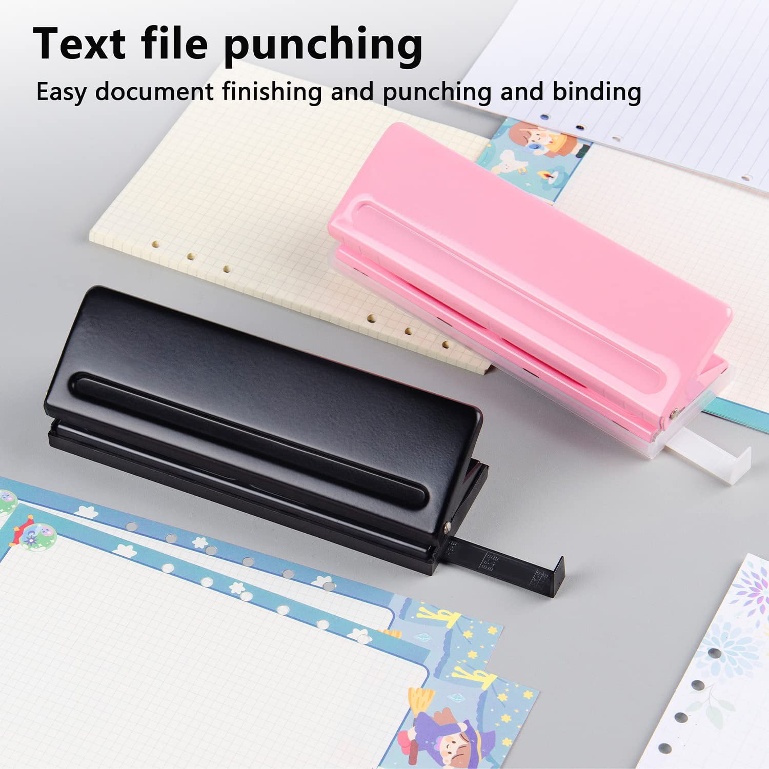 Ein schwarzer und ein pinker Locher liegen auf einem Schreibtisch mit Papier.