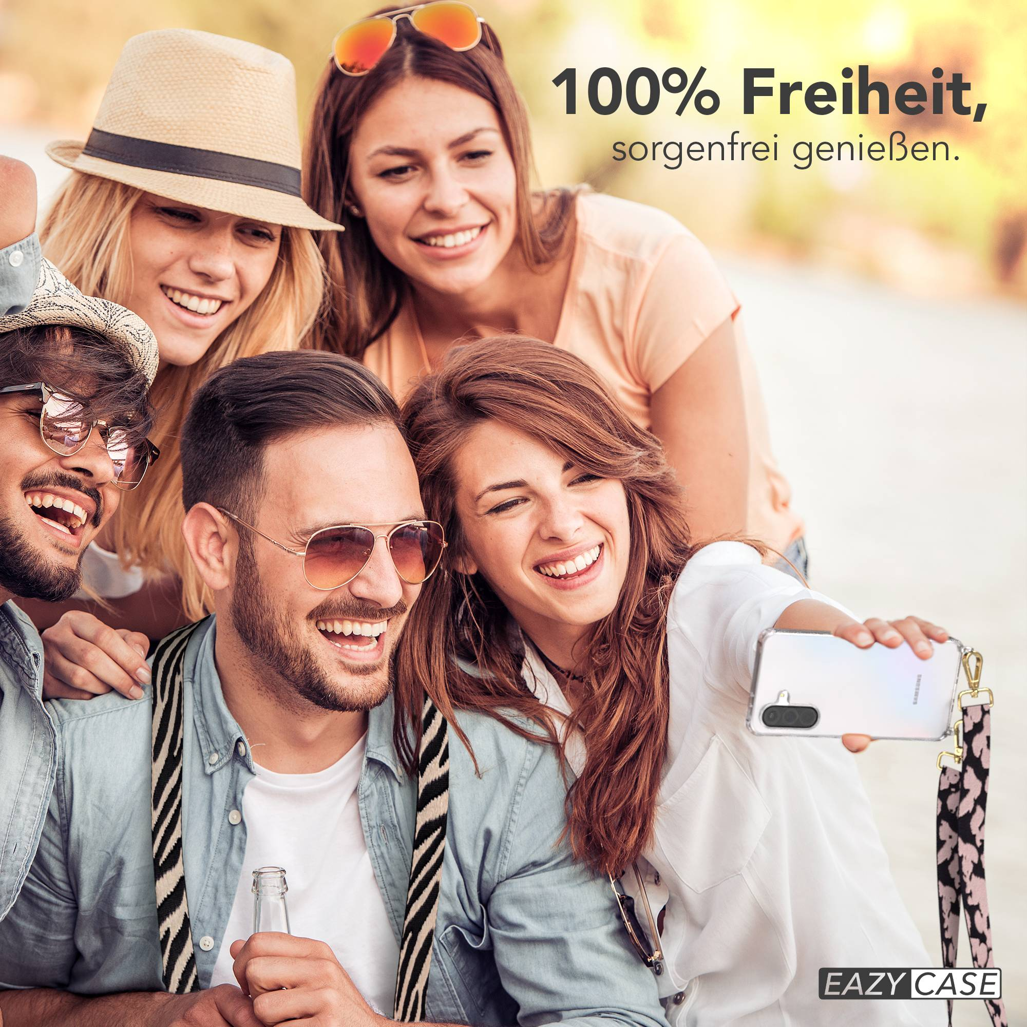 Vier Freunde machen ein Selfie im Freien. Eine Frau hält ein Handy und lächelt. Text: 100% Freiheit, sorgenfrei genießen.