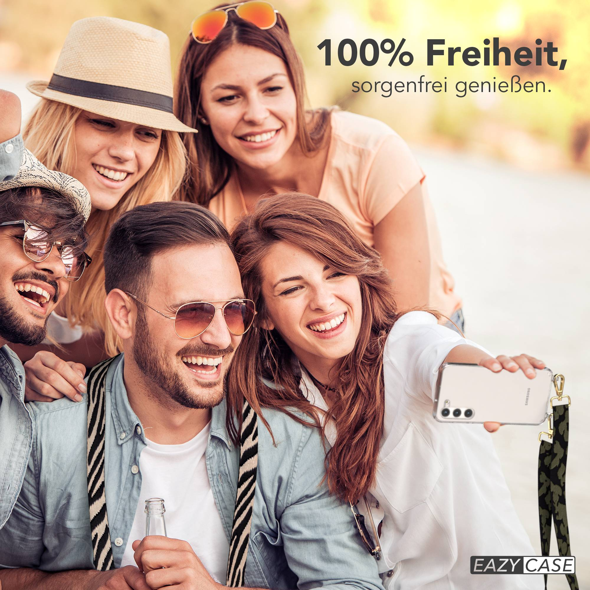 Vier Freunde machen draußen ein Selfie und lächeln. Einer hält ein Handy und eine Flasche.