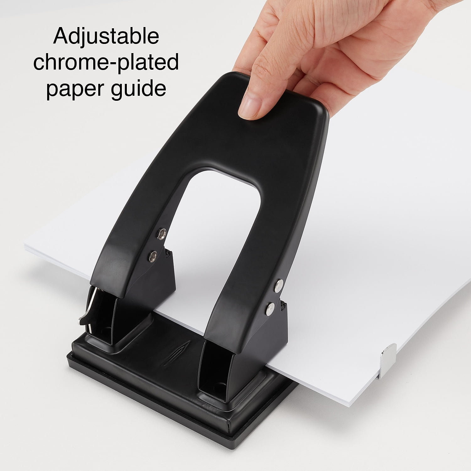 Ein schwarzer Locher wird von einer Hand gehalten, um weißes Papier zu lochen.