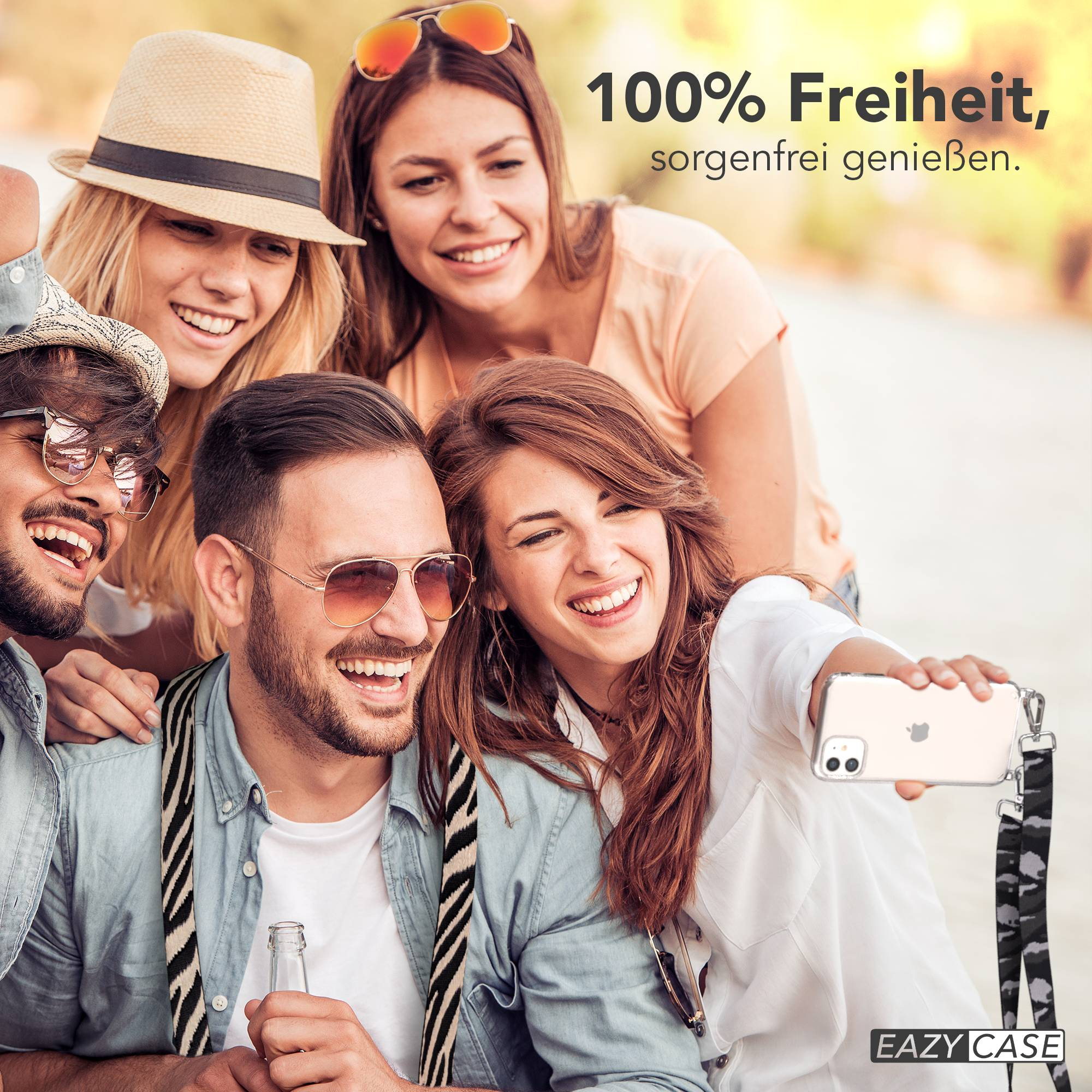 Vier lachende Freunde machen ein Selfie im Freien bei Sonnenschein.