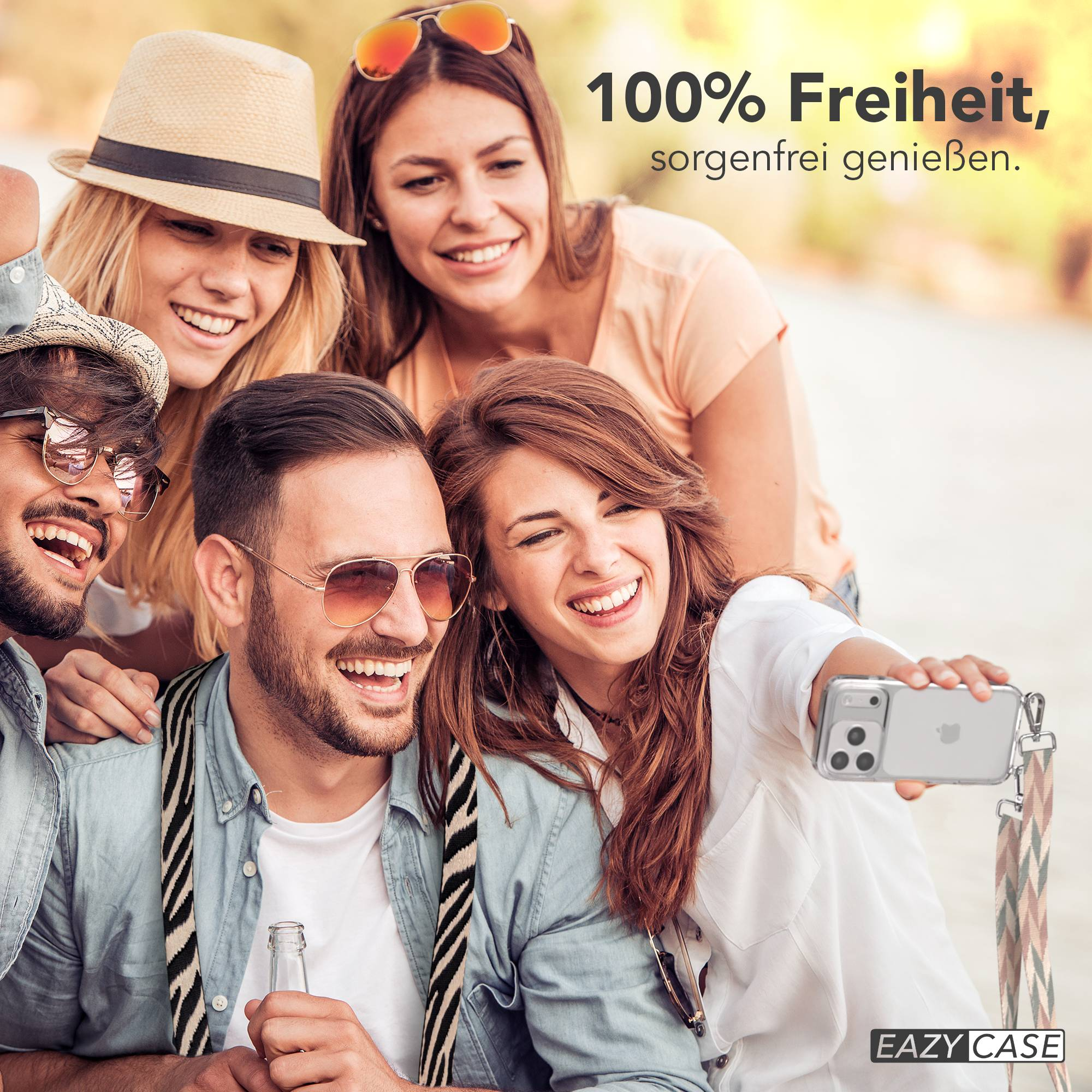 Vier lachende Freunde machen ein Selfie im Freien mit einem Smartphone.
