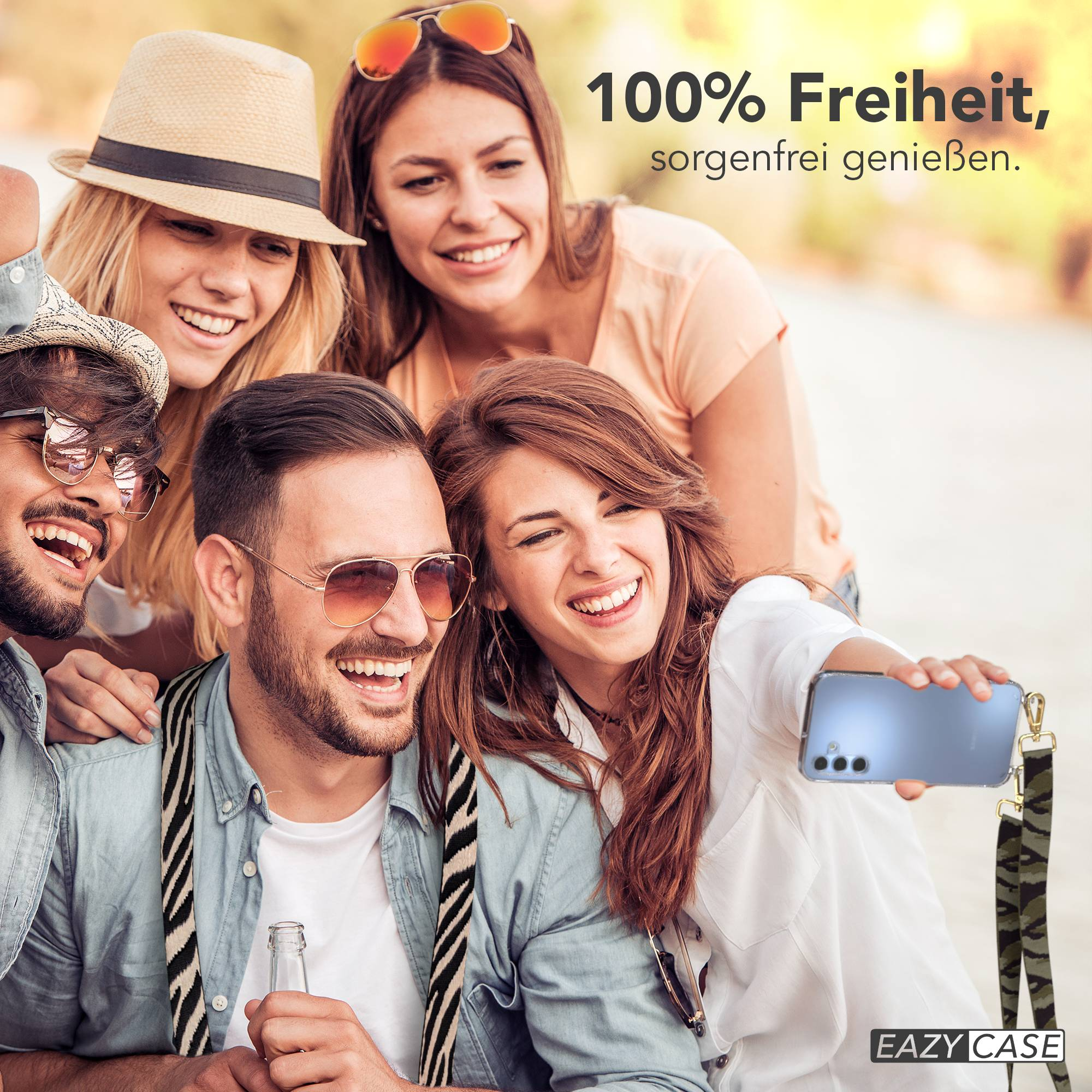 Vier Freunde machen ein Selfie im Freien, lächelnd und lachend. Einer hält ein Handy.