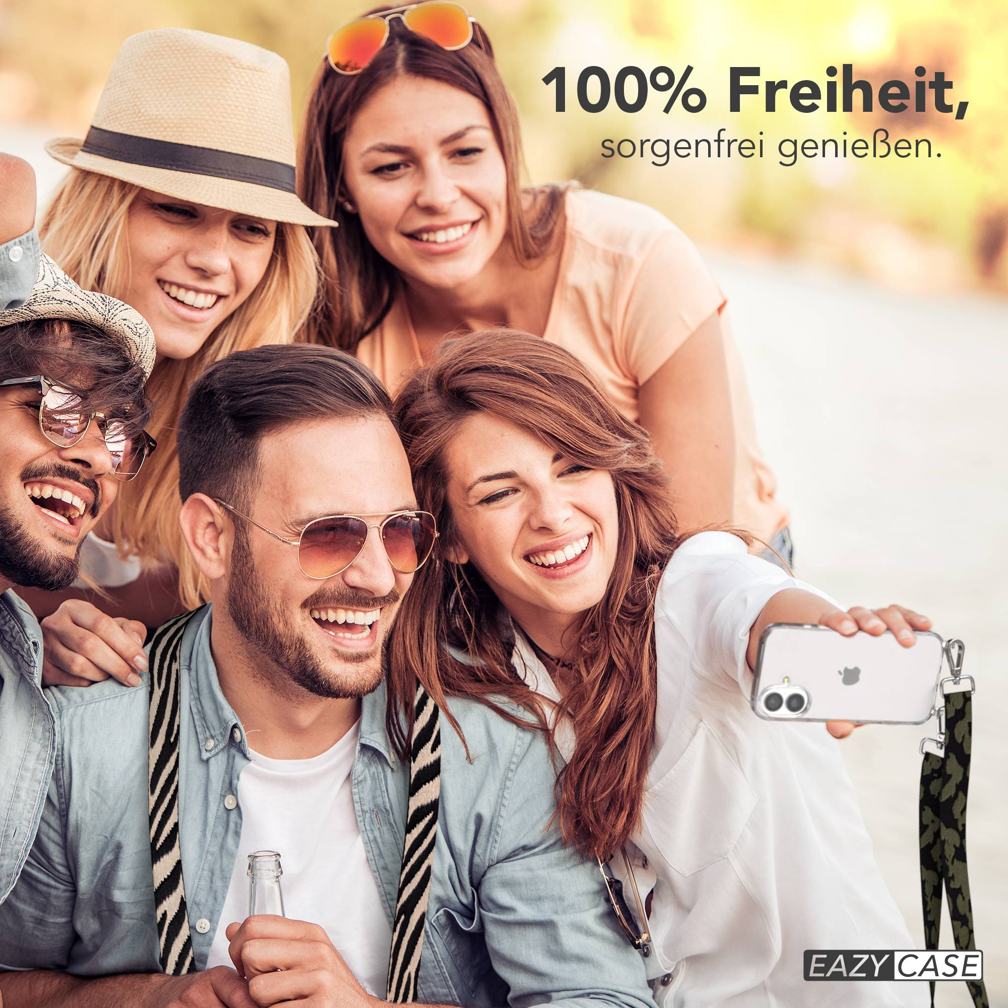 Vier Freunde machen draußen ein Selfie und lächeln. Einer hält ein Handy und eine Flasche.