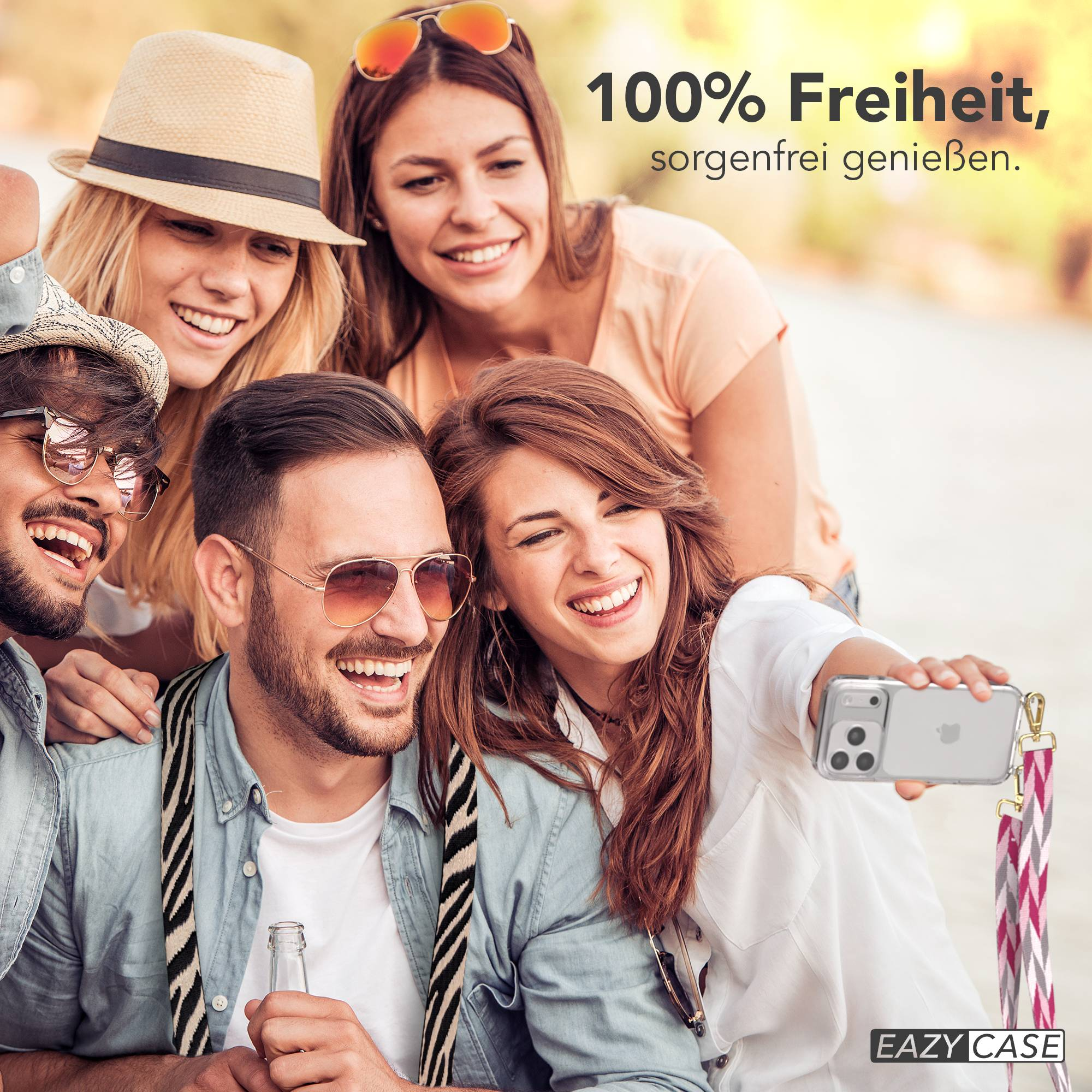 Vier lachende Freunde machen ein Selfie im Freien mit einem Handy.
