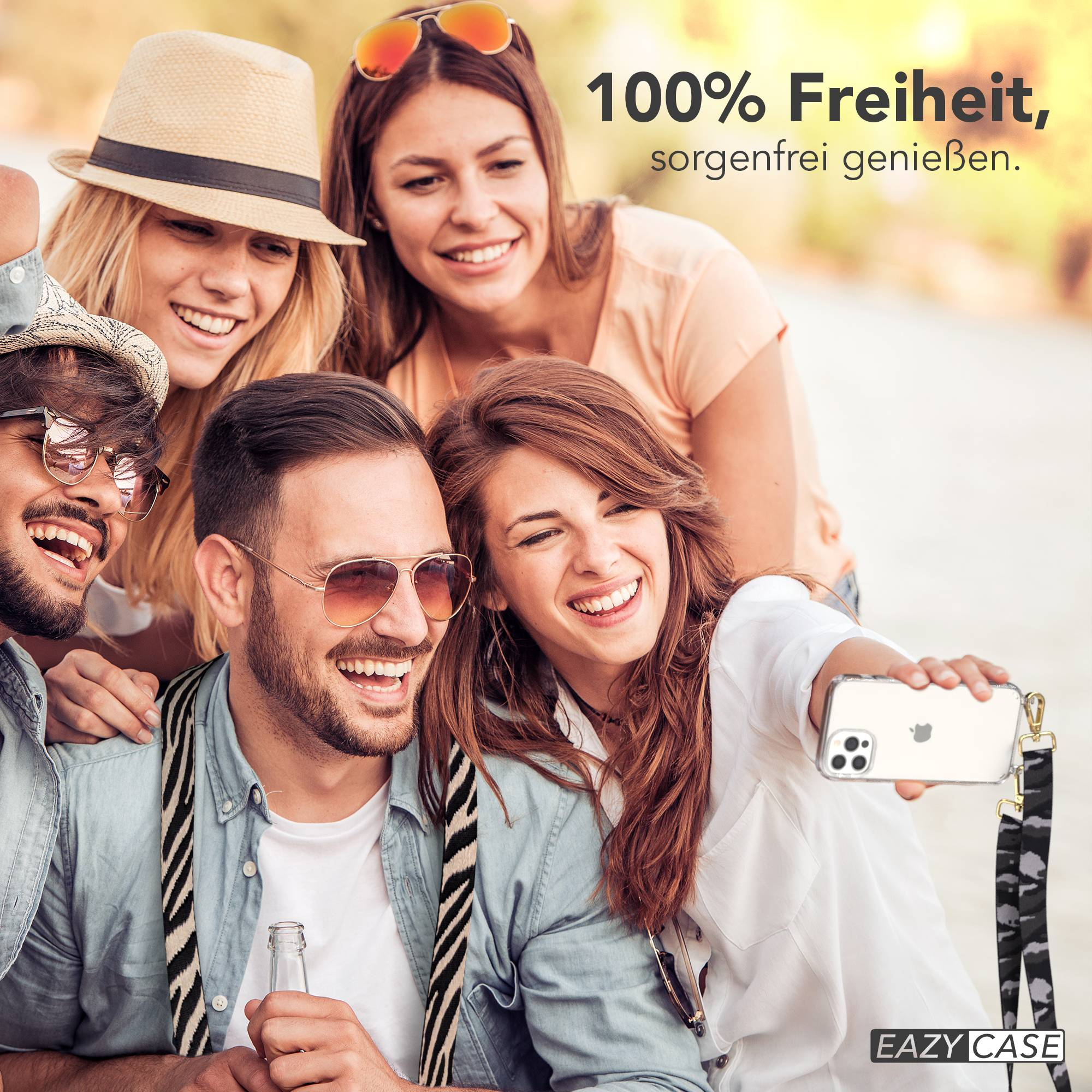 Vier lachende Freunde machen ein Selfie. Einer hält ein Handy.