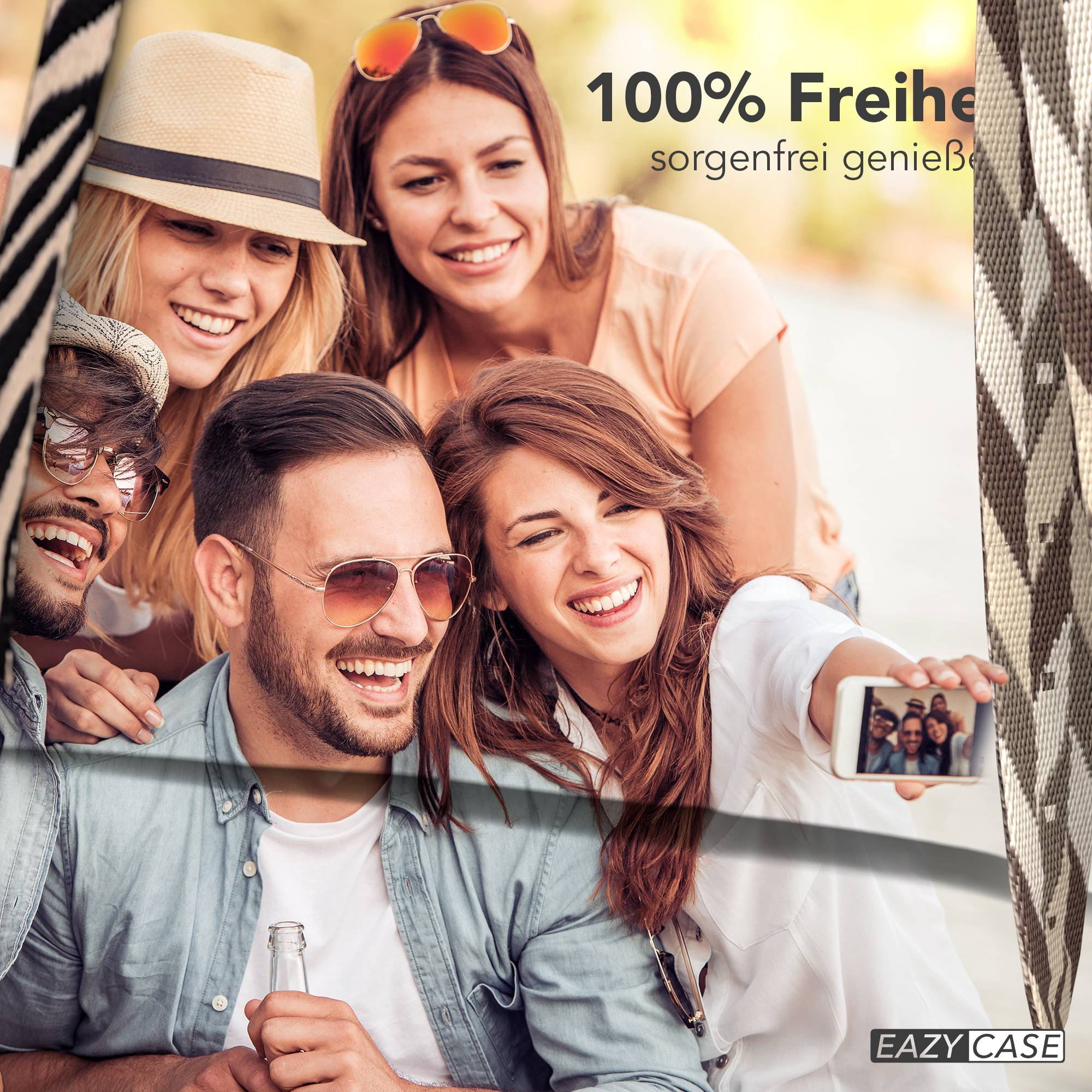 Vier lächelnde Freunde machen draußen ein Selfie, zwei Männer, zwei Frauen.