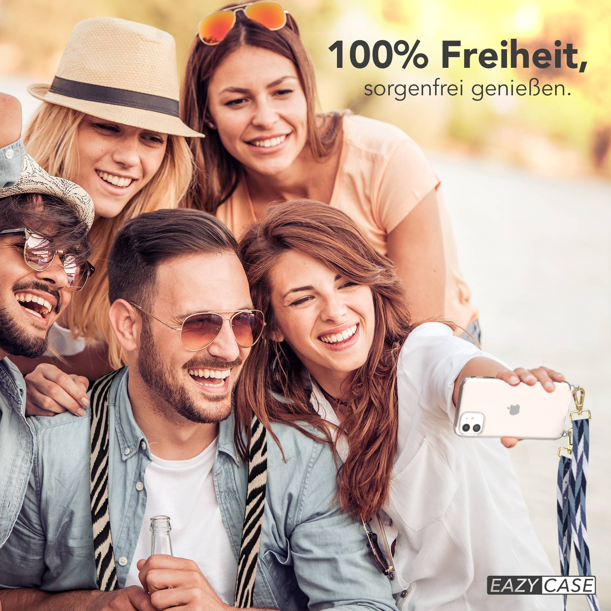 Vier Freunde machen draußen ein Selfie, lächelnd, mit Handy und Flasche sichtbar.