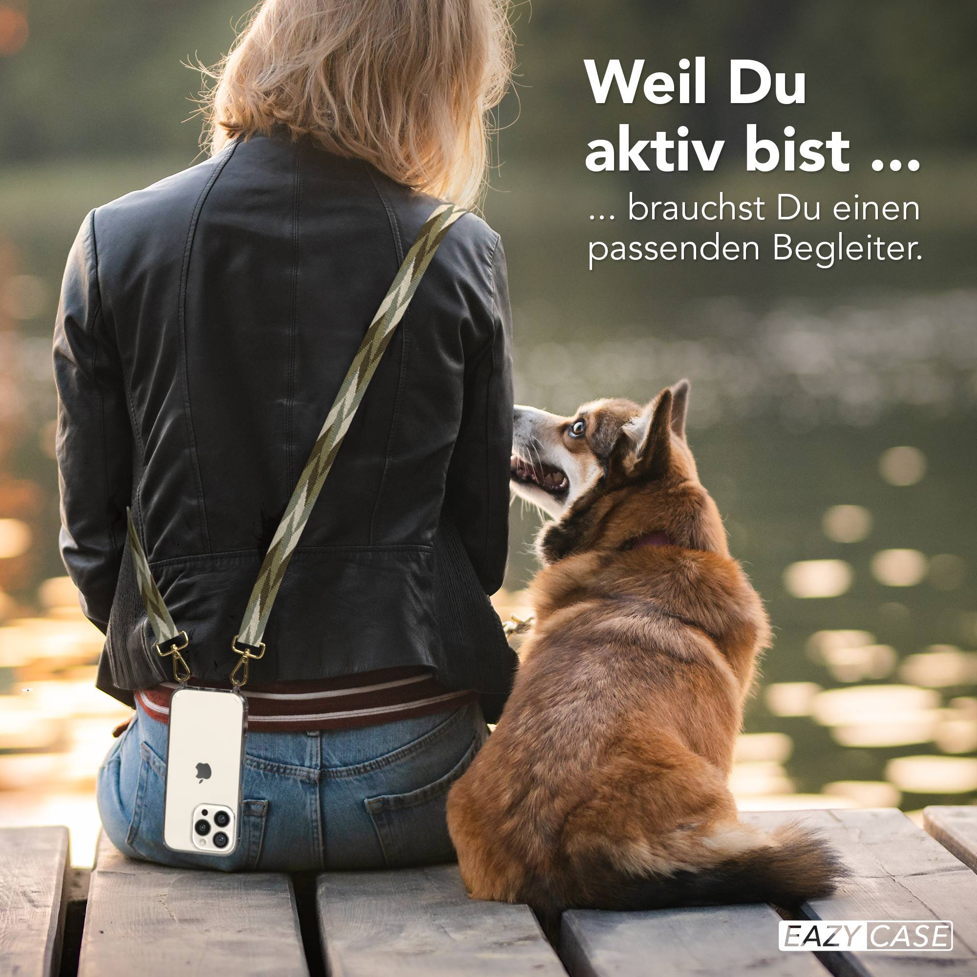 Frau mit Hund sitzt auf Holzsteg am Wasser. iPhone am Gurt.