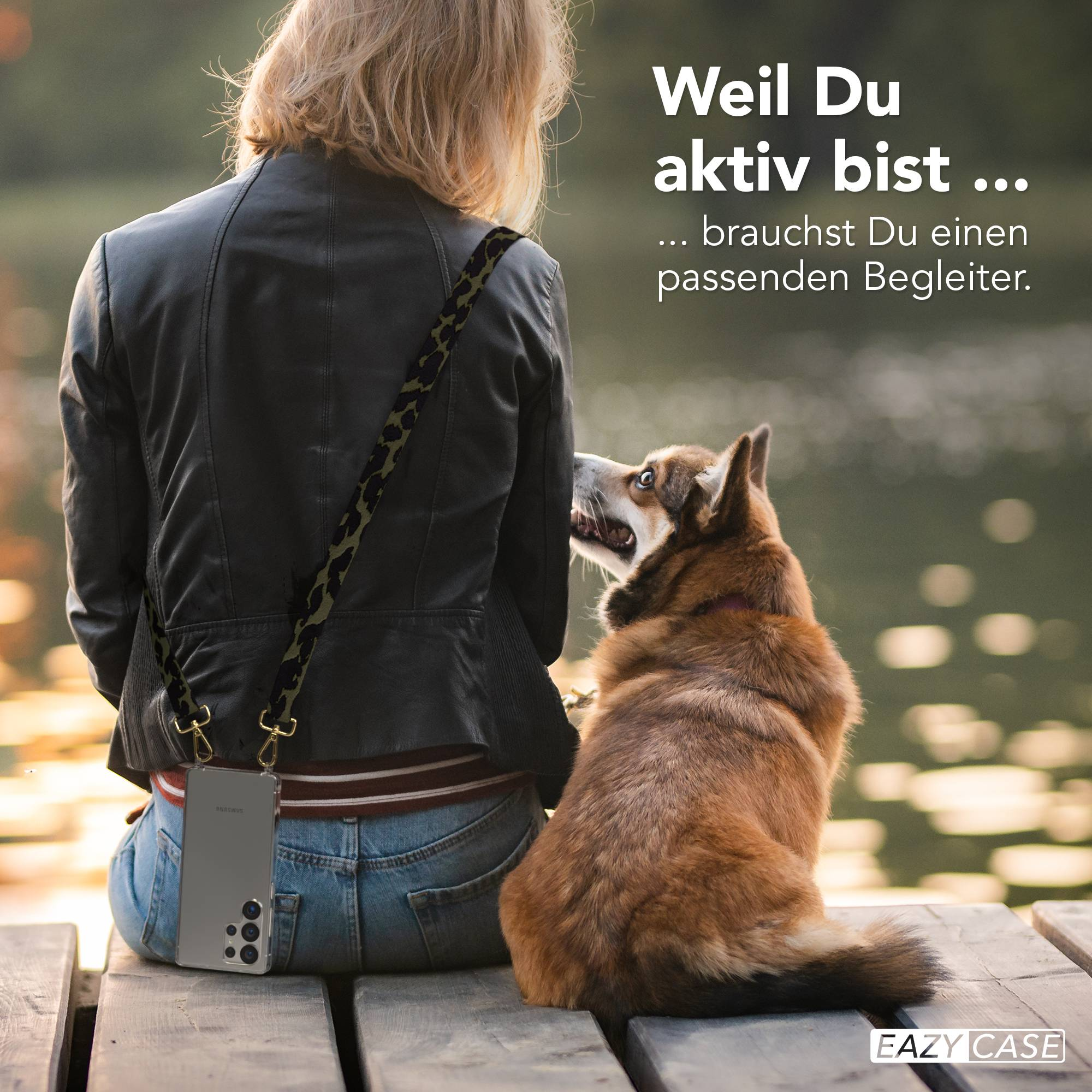 Eine Frau mit einem Hund sitzt auf einer Holzbank am Wasser. Eine Handyhülle ist zu sehen.
