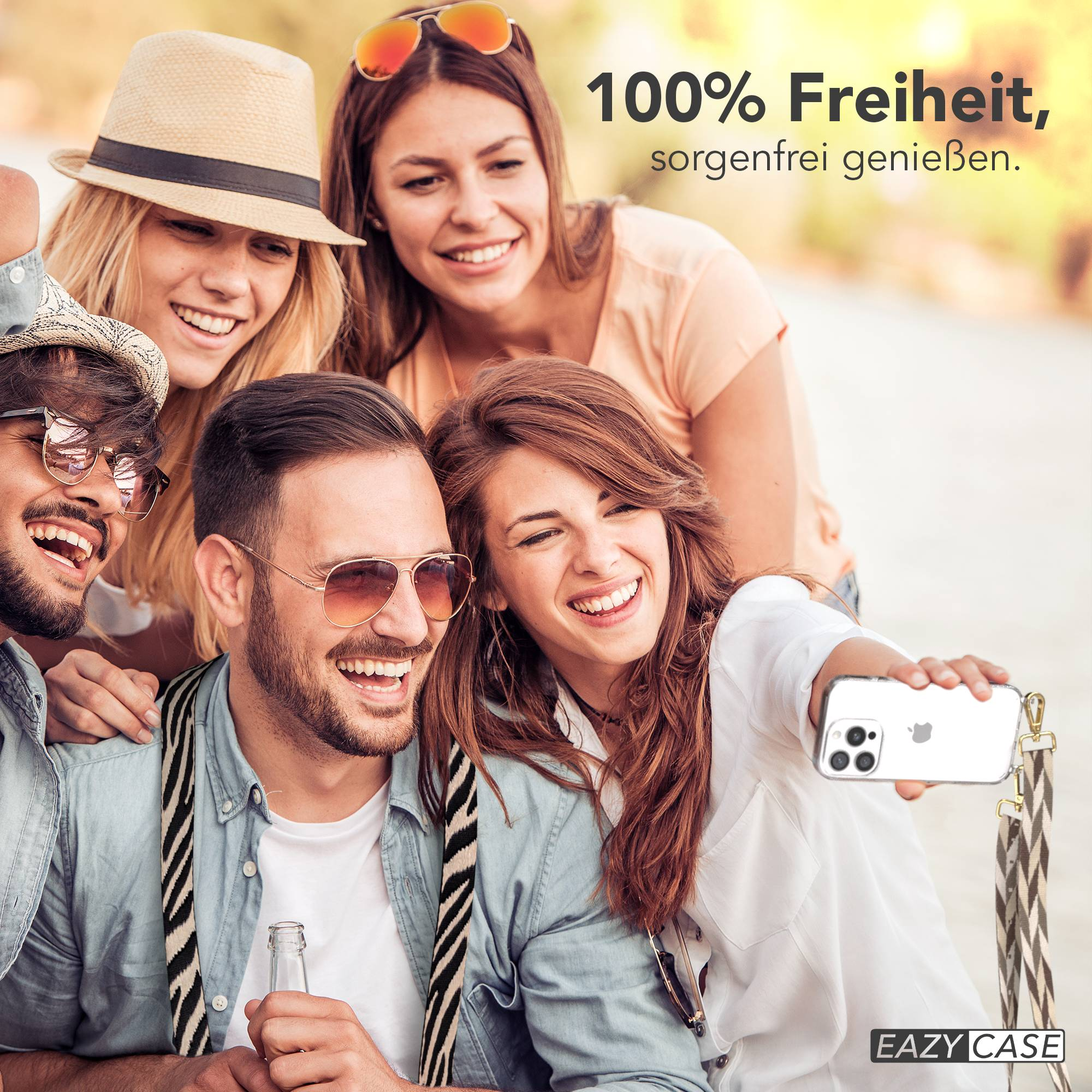 Vier Freunde machen draußen ein Selfie, lächelnd und ein Handy haltend.