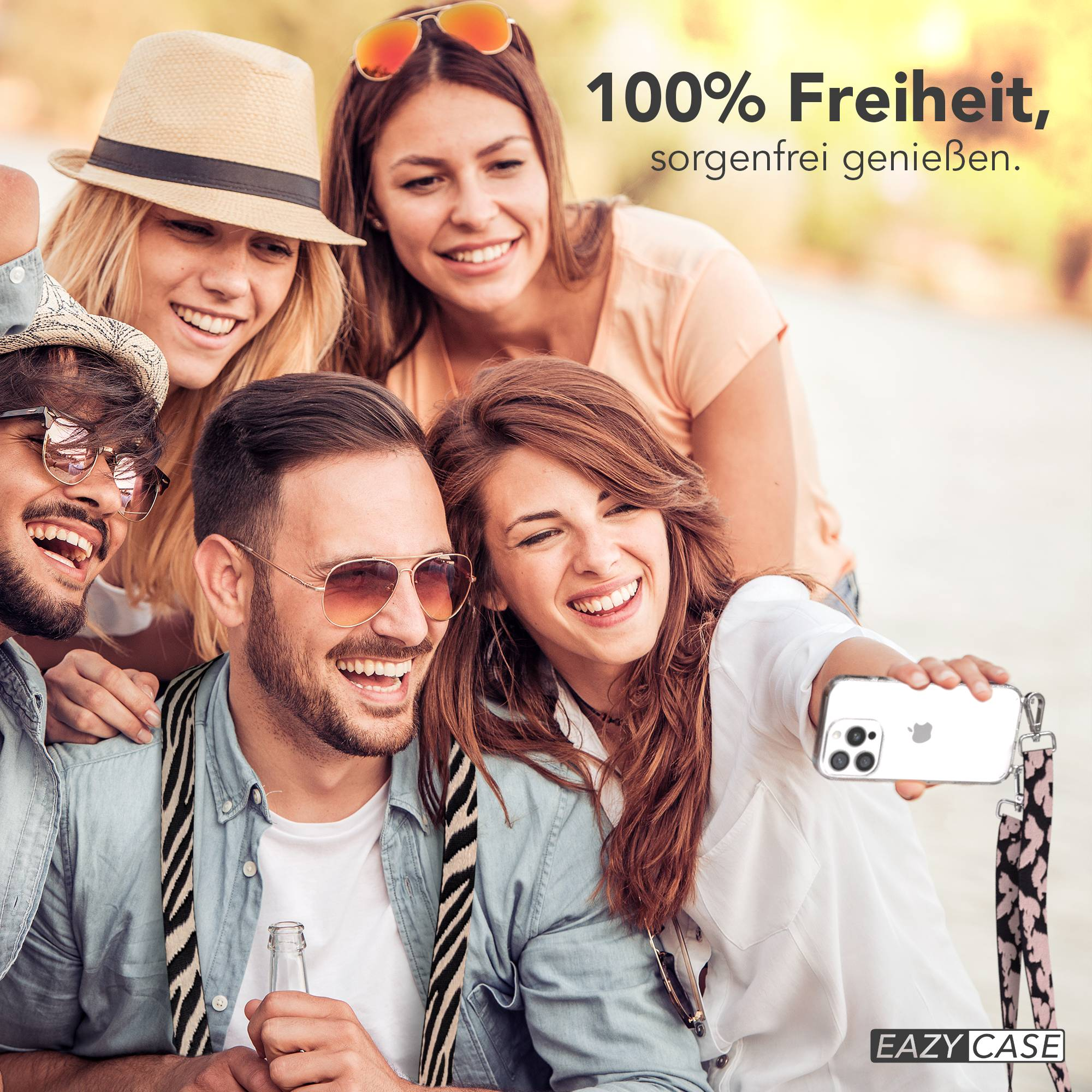 Freunde machen draußen ein Selfie, lächelnd und ein Handy haltend. Text: 100% Freiheit.