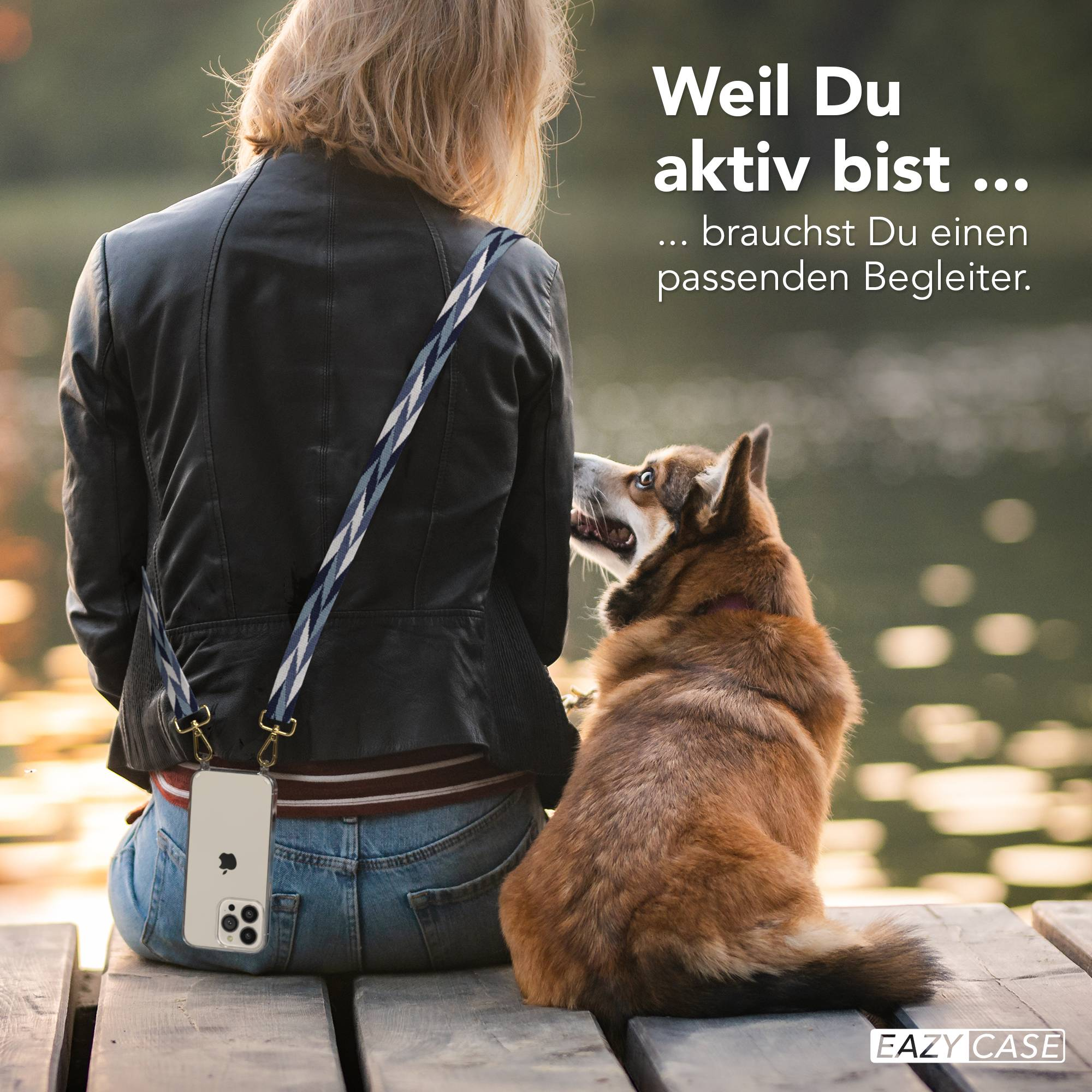 Frau in schwarzer Jacke mit Handyhülle sitzt auf Holzsteg mit Hund.