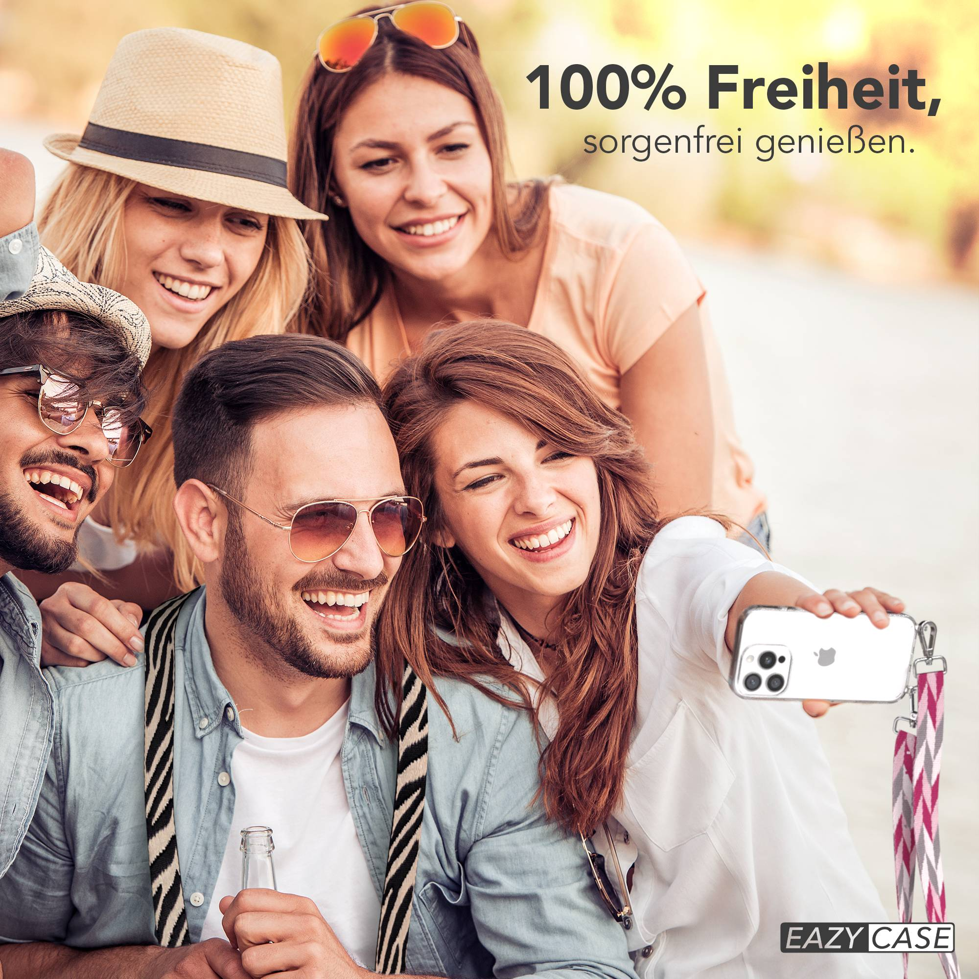 Vier lachende Freunde machen ein Selfie mit einem Handy, eine Frau hält das Handy.