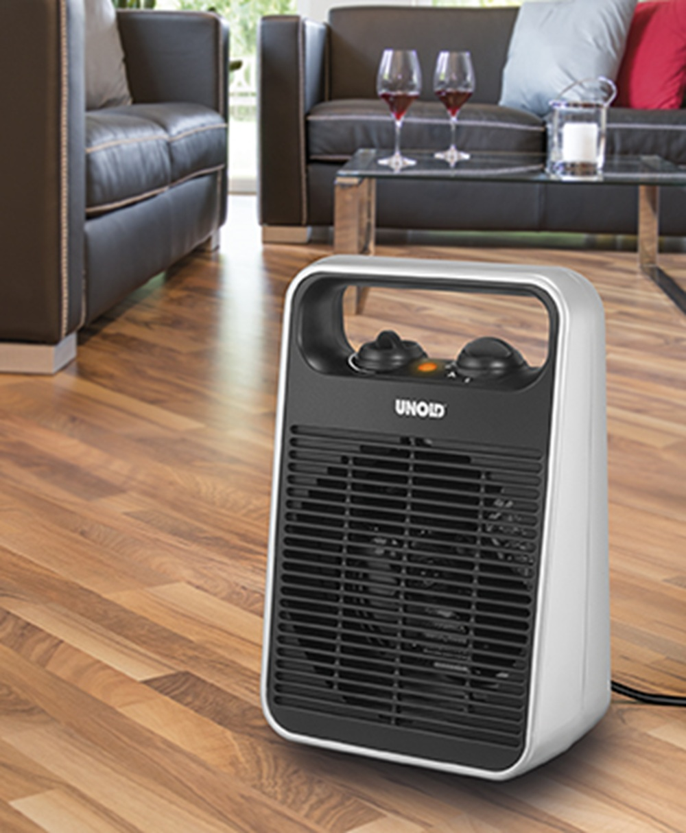 Biały i czarny grzejnik Unold stoi na drewnianej podłodze w salonie.