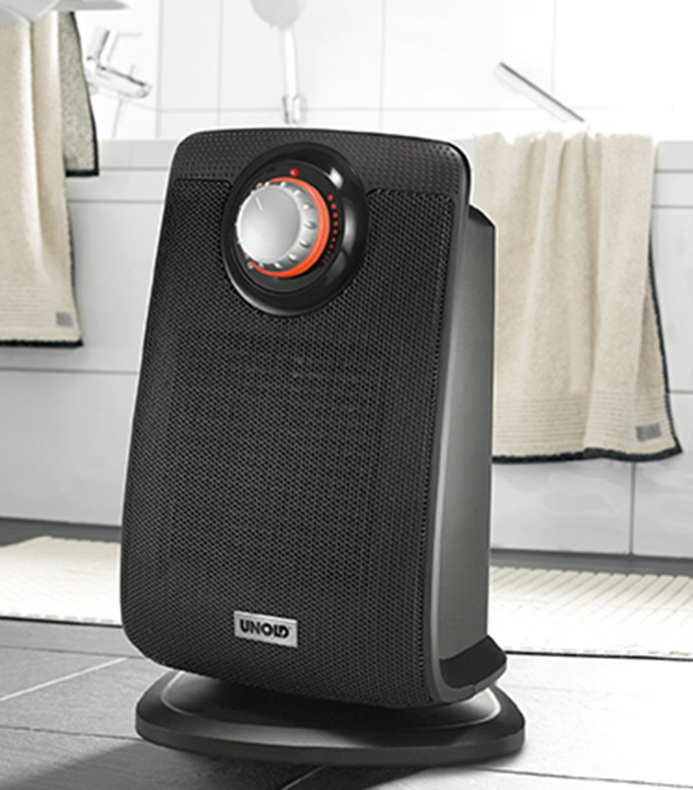 Czarny grzejnik łazienkowy UNOLD z pokrętłem stoi na podłodze łazienki.