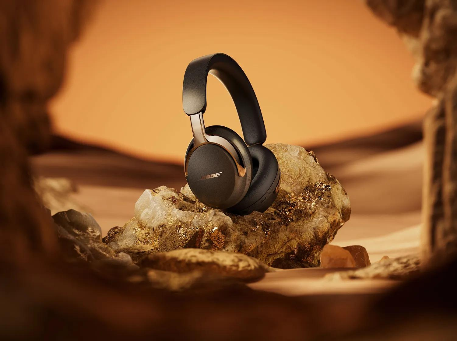 Auriculares Bose negros con detalles en cobre sobre una roca.