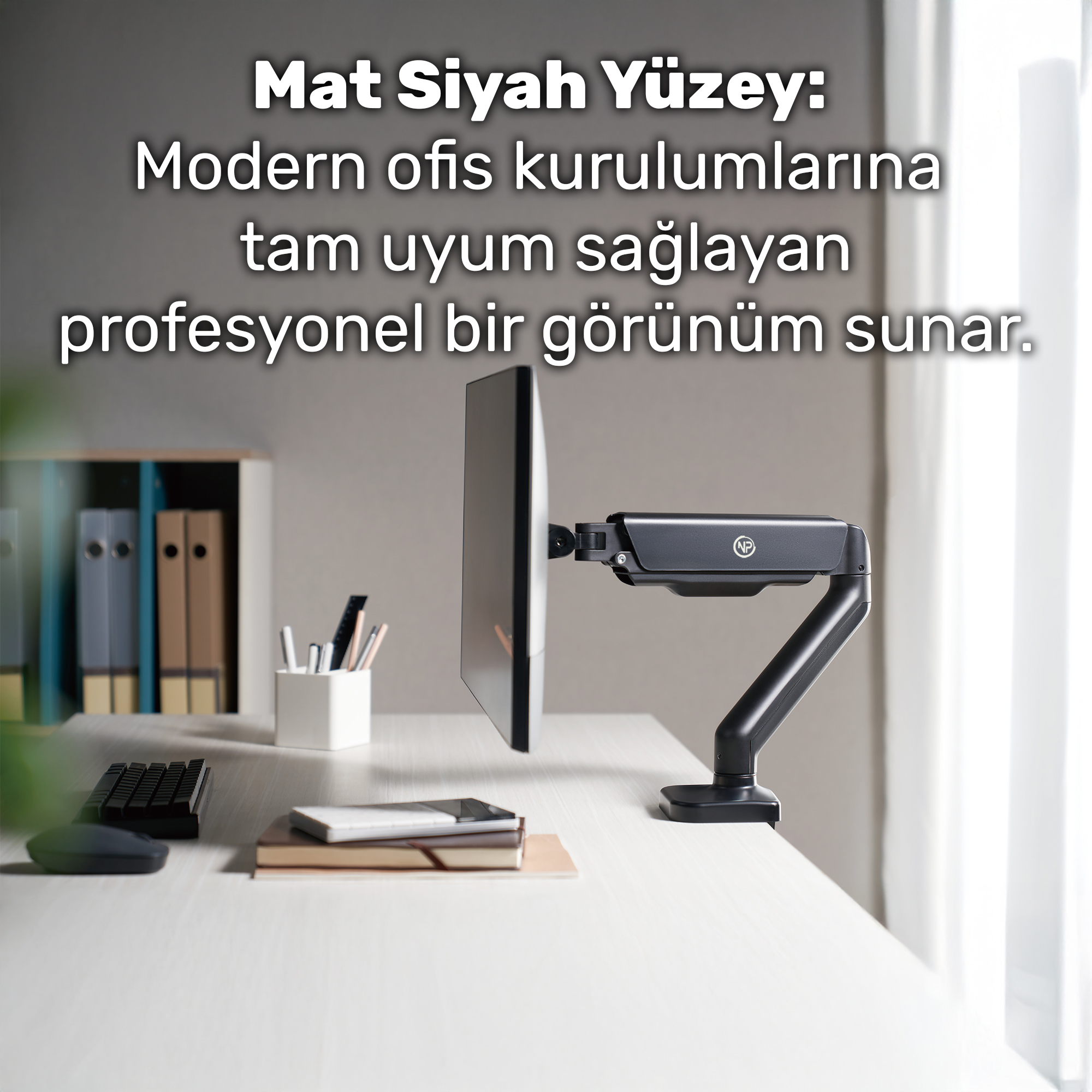 Bir monitör kolu, ofis malzemelerinin bulunduğu bir masanın üzerinde bir ekran tutuyor.