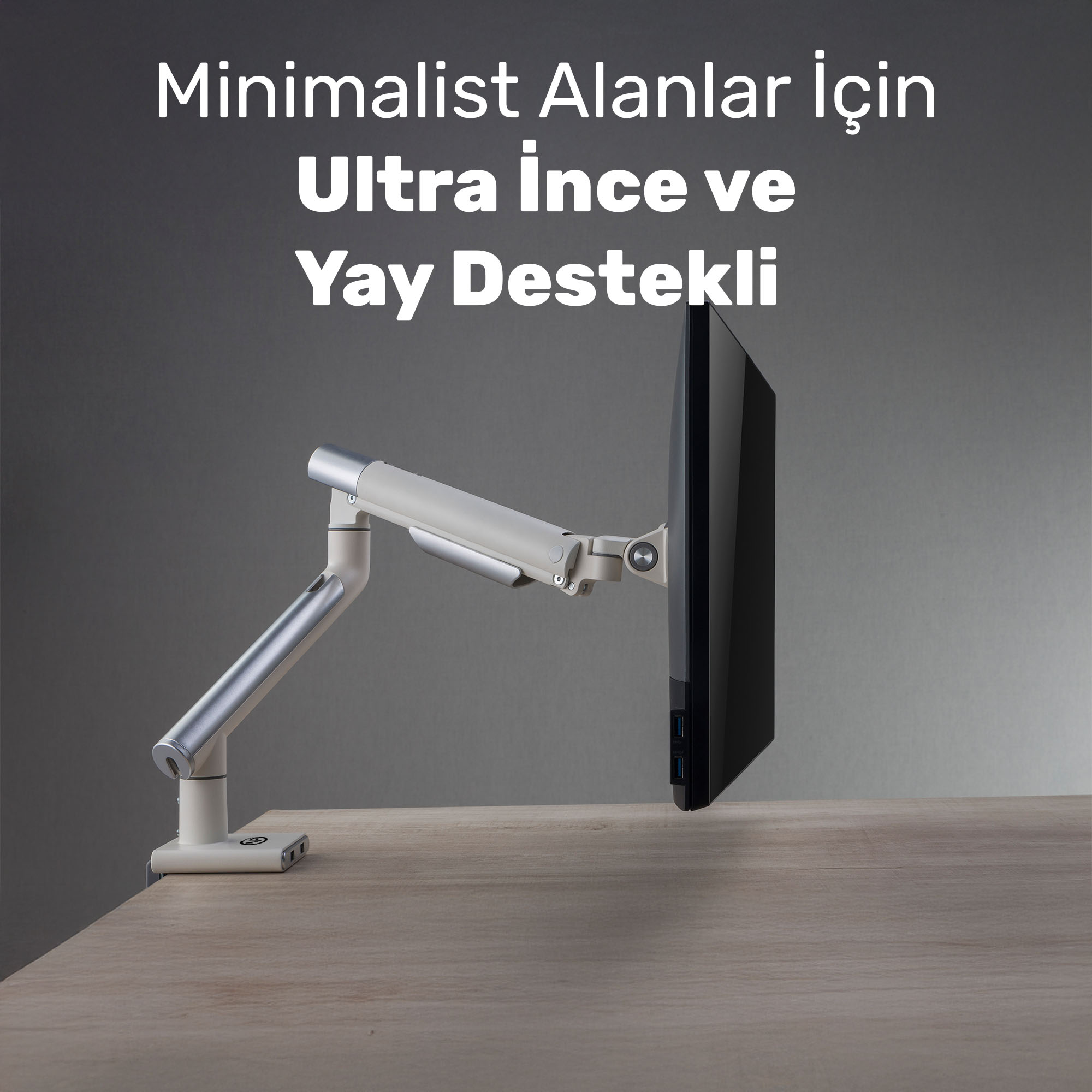 Şık tasarımlı bir monitör kolu, ahşap bir masada siyah bir monitörü tutuyor.