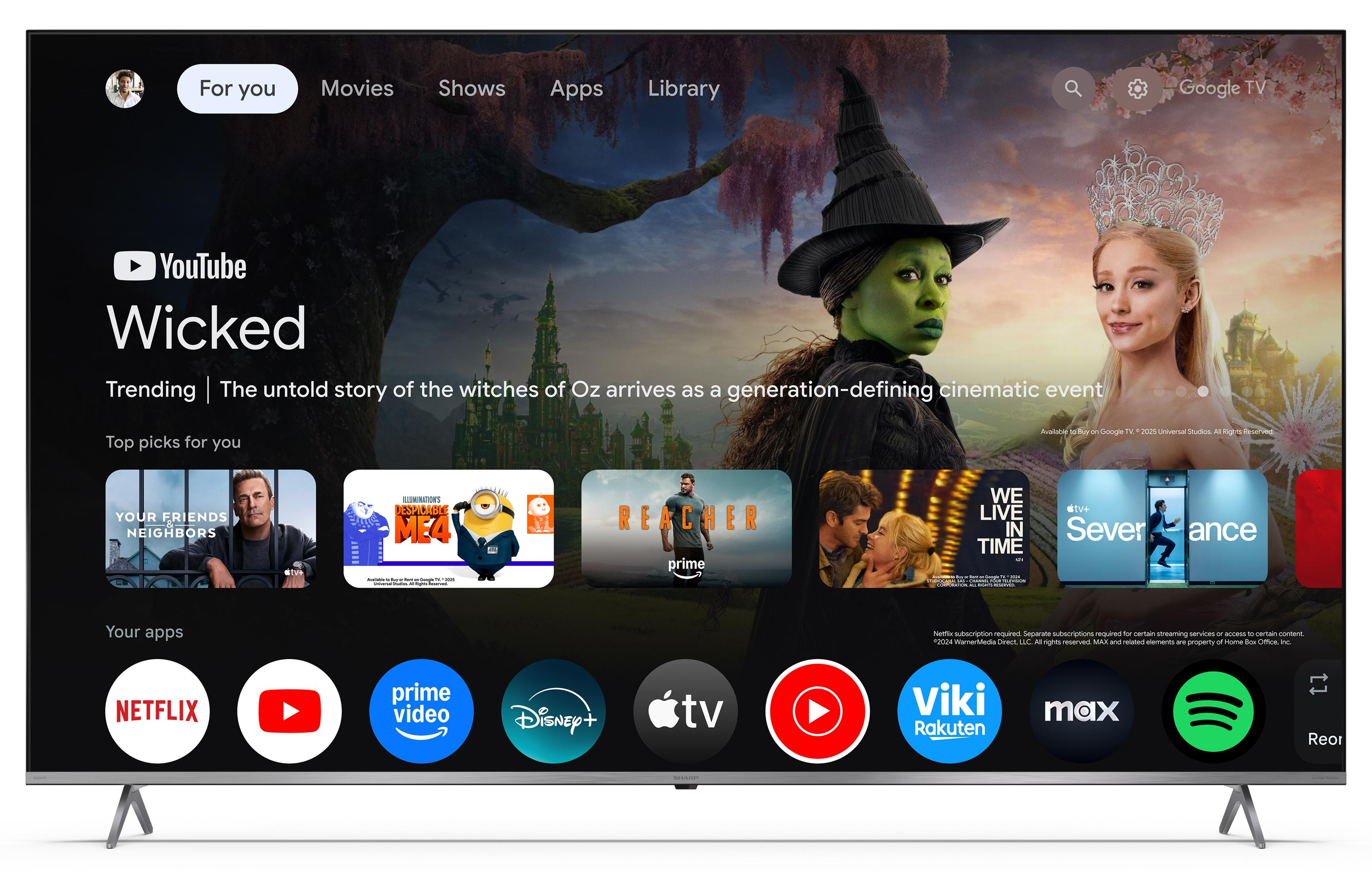 Uno schermo TV mostra un'interfaccia Google TV con titoli di film e icone di app.