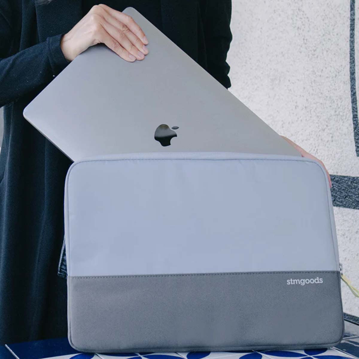 Un laptop grigio viene inserito in una custodia per laptop bicolore.