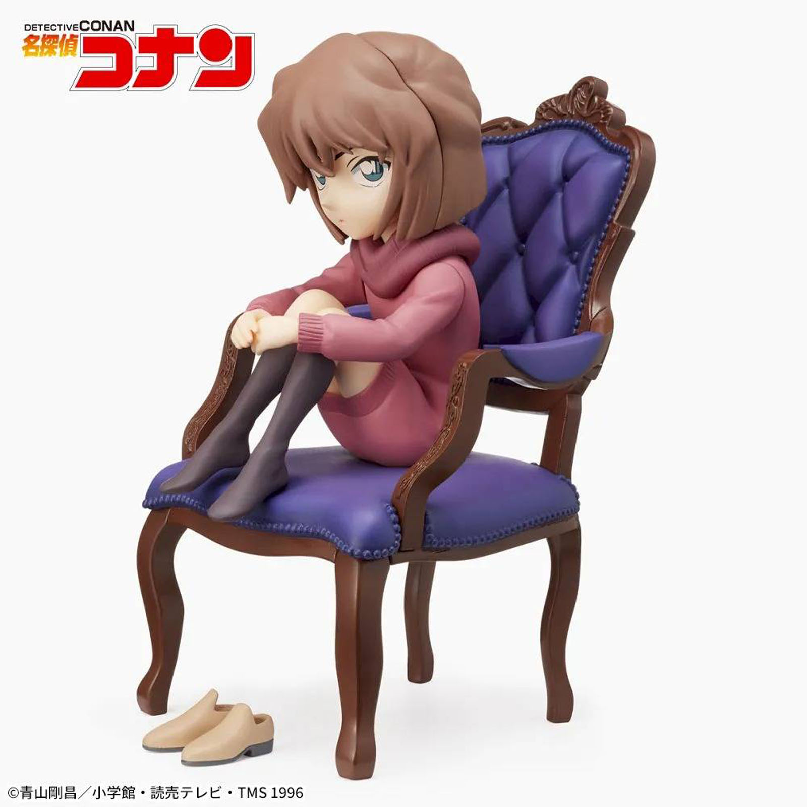 Eine Figur sitzt auf einem lilafarbenen Sessel, daneben stehen Schuhe.