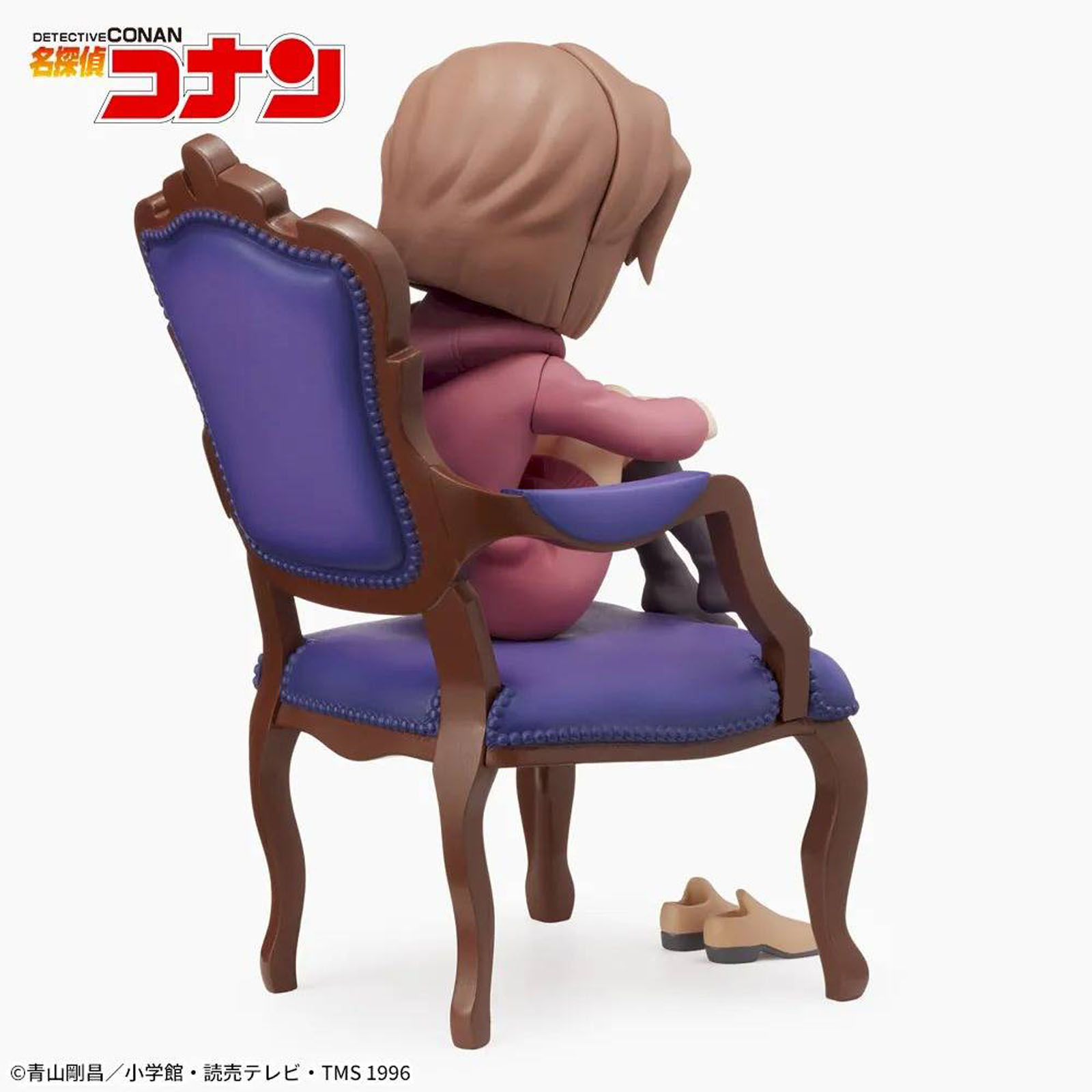Eine Figur sitzt auf einem violetten Stuhl, Schuhe liegen daneben.