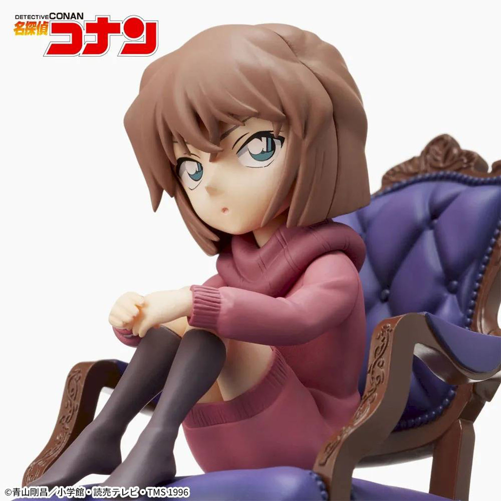Eine Figur sitzt auf einem lila Sessel, trägt einen rosa Pullover und dunkle Strümpfe.