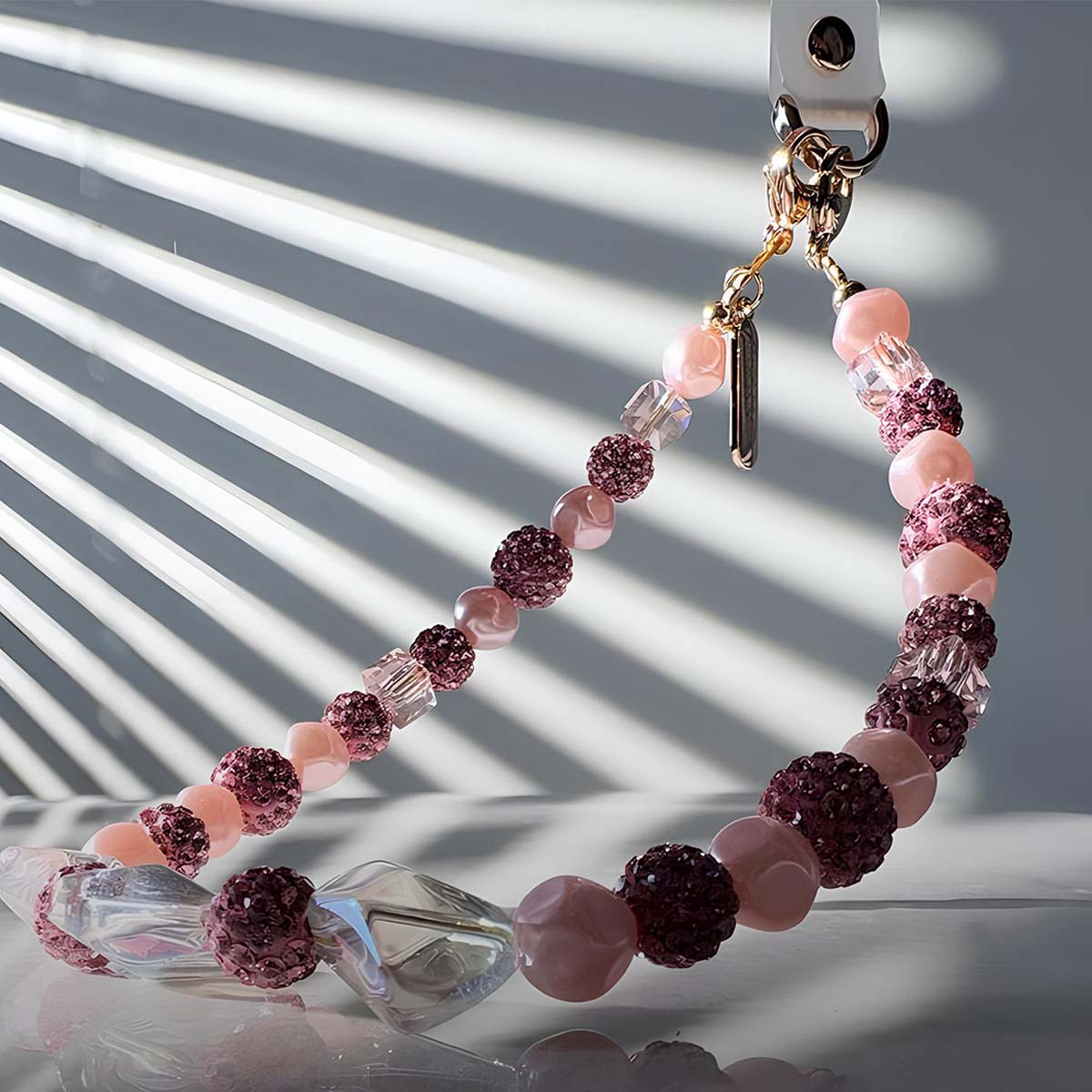 Una collana di perline rosa e viola con accenti glitterati e di cristallo.