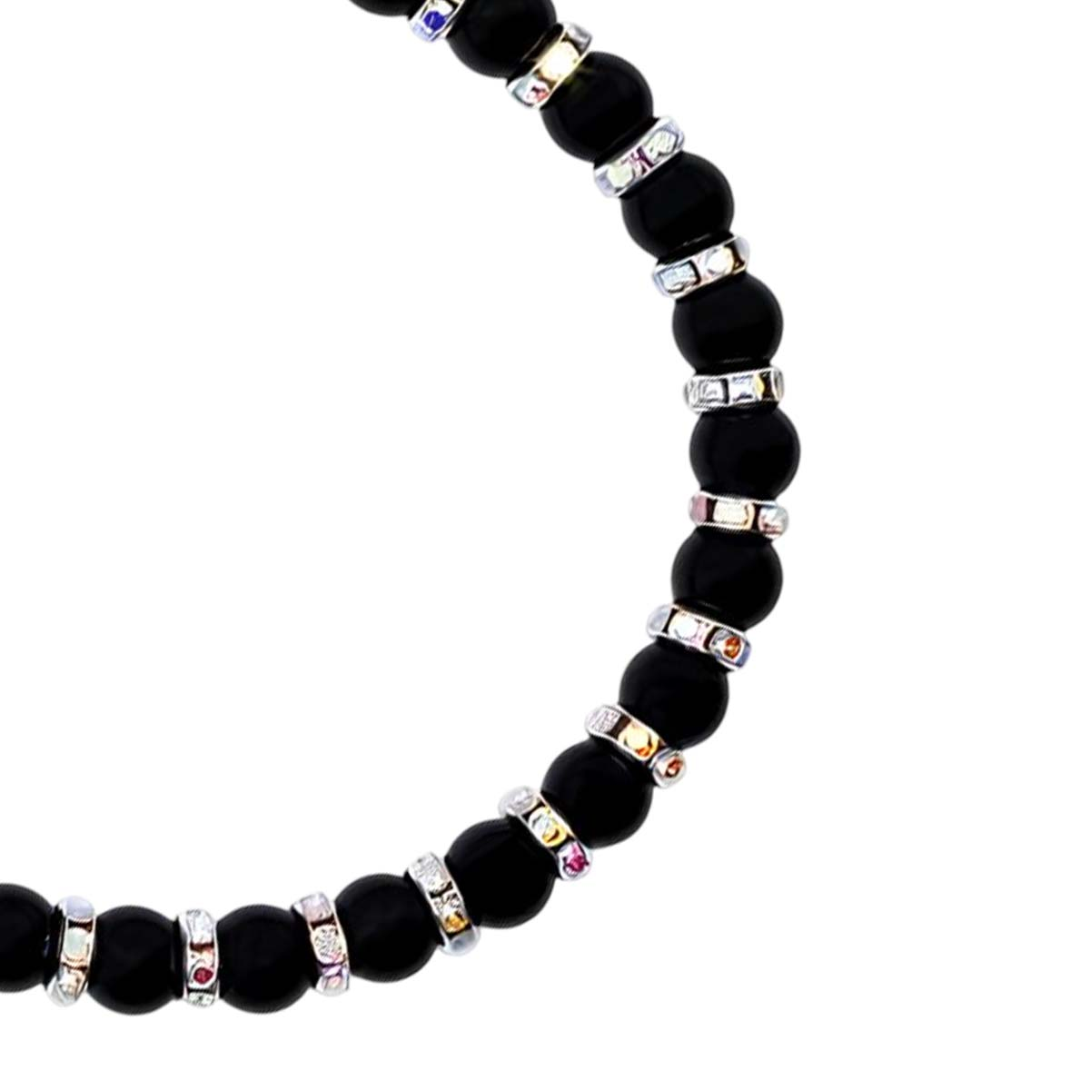 Un bracciale di perline nere con anelli d'accento argentati e colorati.