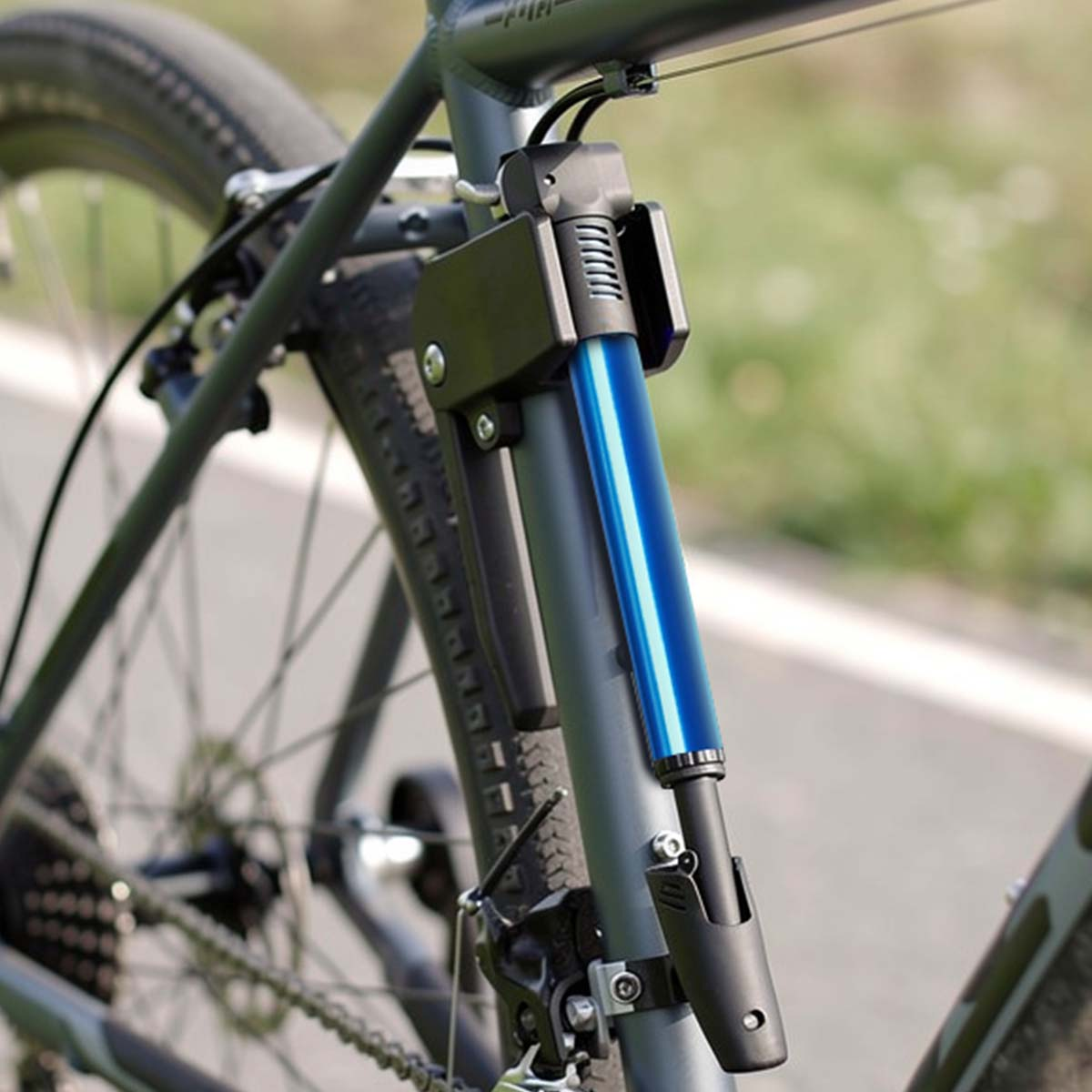 Ein blauer Fahrradpumpenaufsatz ist am Rahmen eines Fahrrads befestigt.