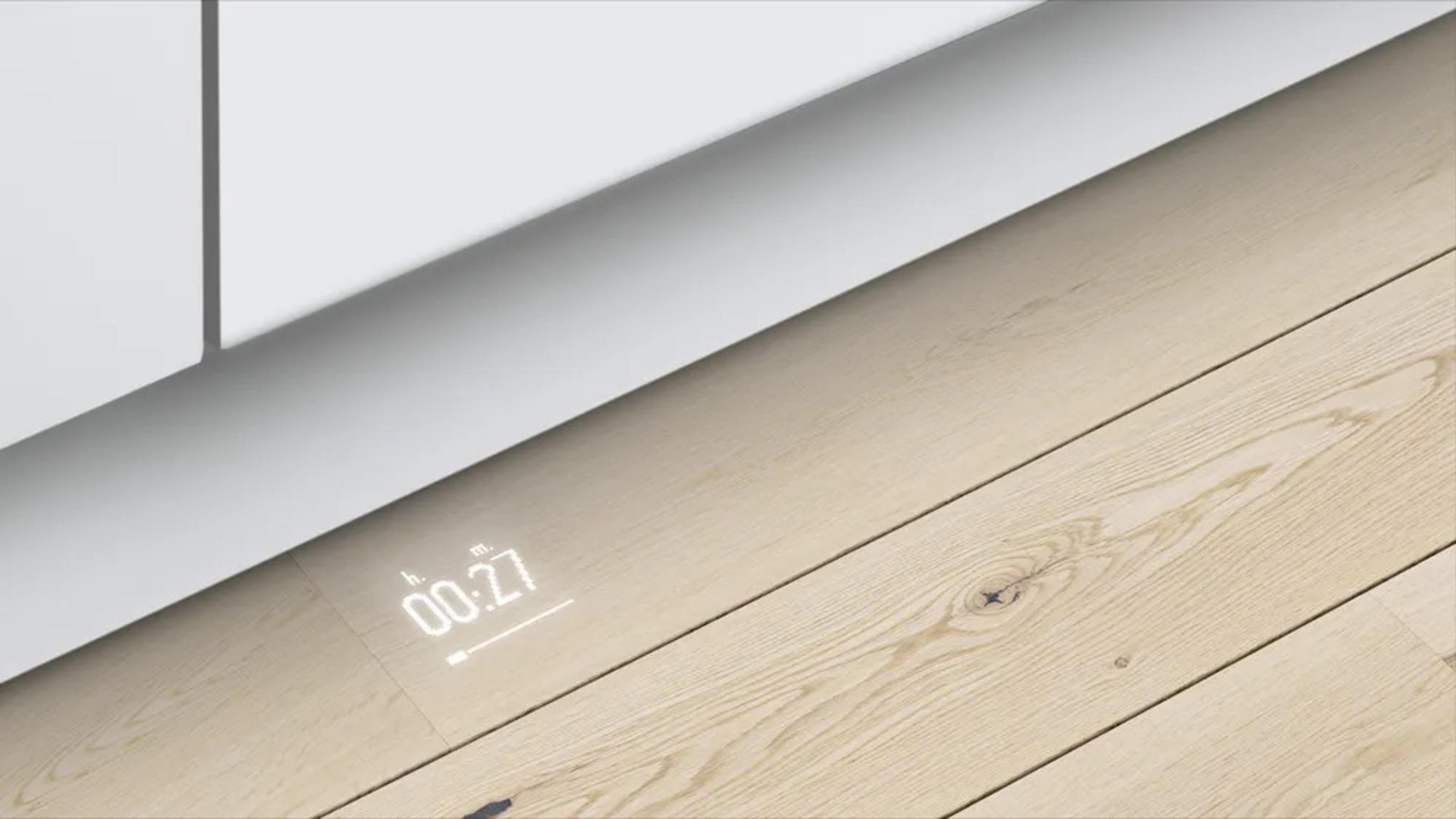 Un display digitale mostra 00:27 su un pavimento in legno chiaro.