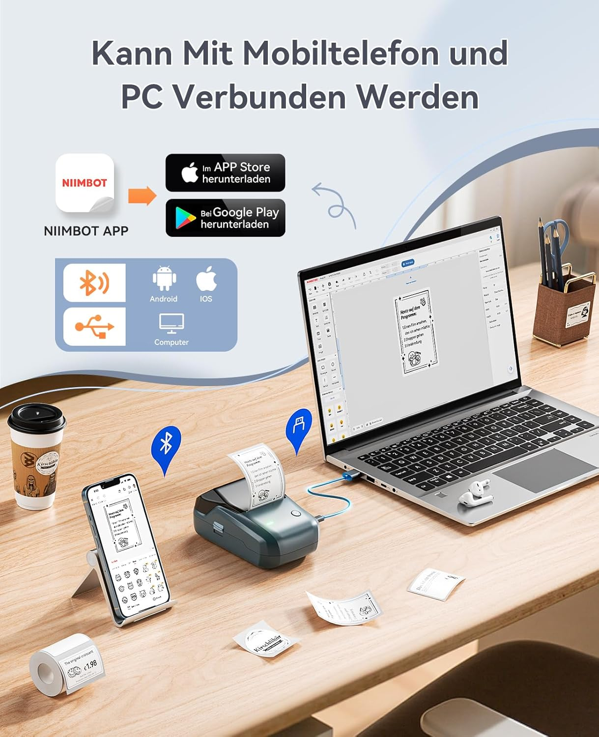 Ein Drucker, Smartphone, Laptop und Kaffeebecher auf einem Schreibtisch. Text: "Kann mit Mobiltelefon und PC verbunden werden."