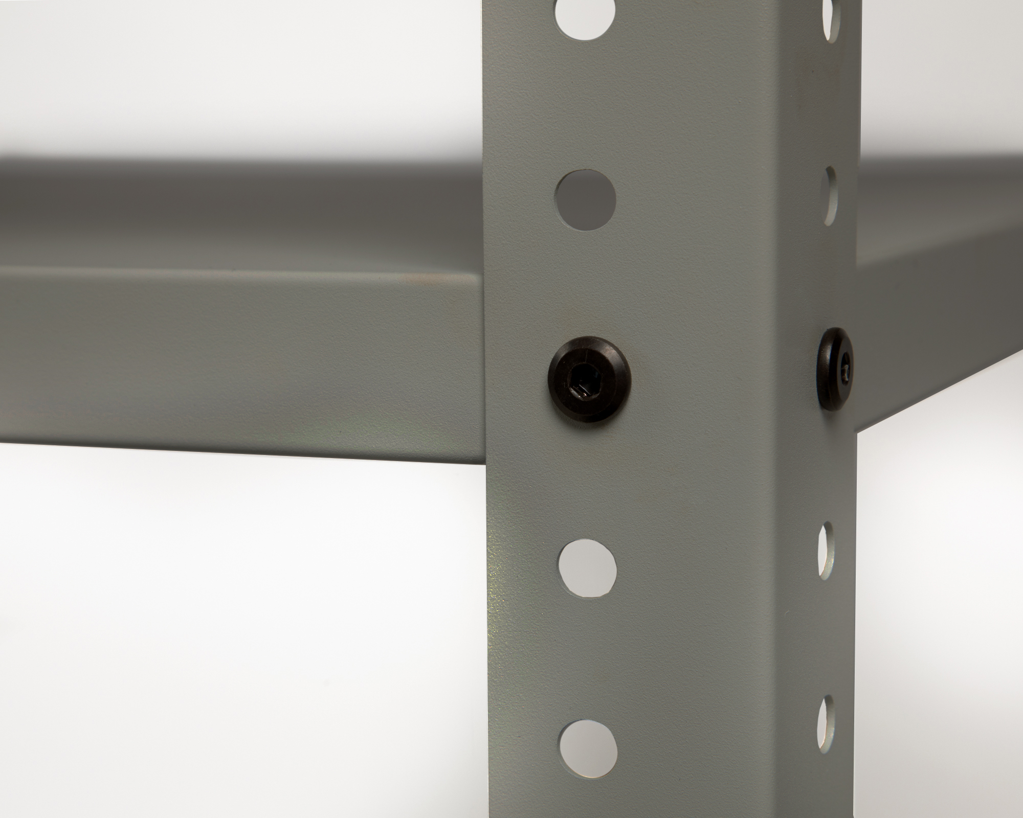 Graues Metallregal mit Schrauben und runden Löchern im Detail.