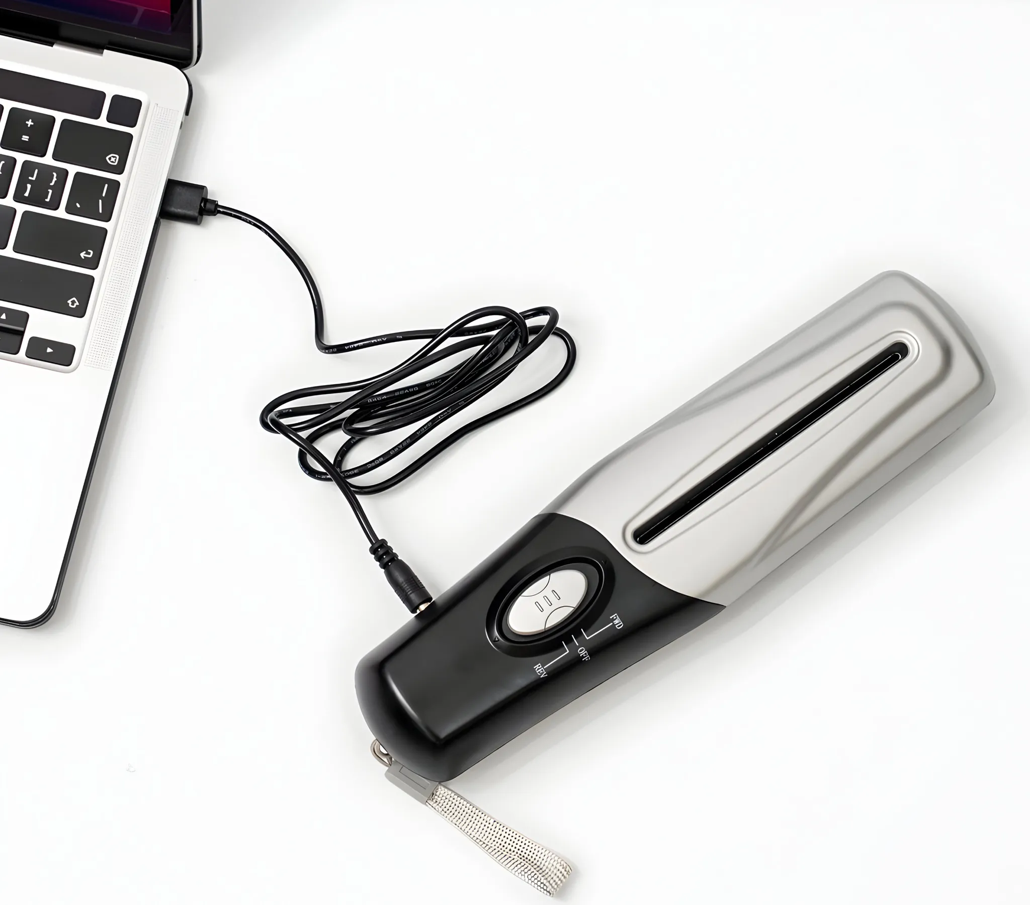 Ein schwarzes Kabel verbindet einen Laptop mit einem silbernen und schwarzen Gerät.