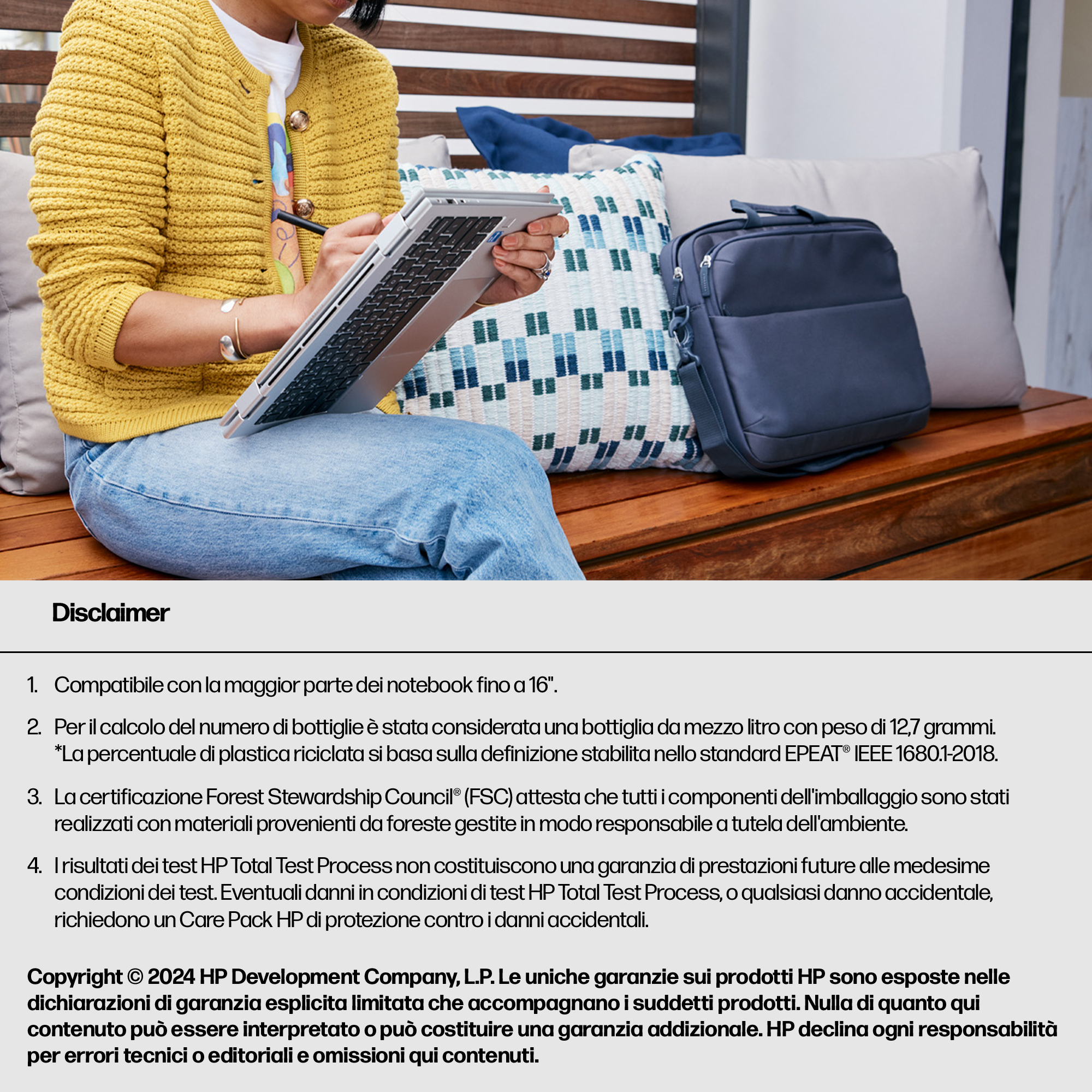Eine Person in einem gelben Strickcardigan sitzt mit einem Laptop und einer blauen Tasche.