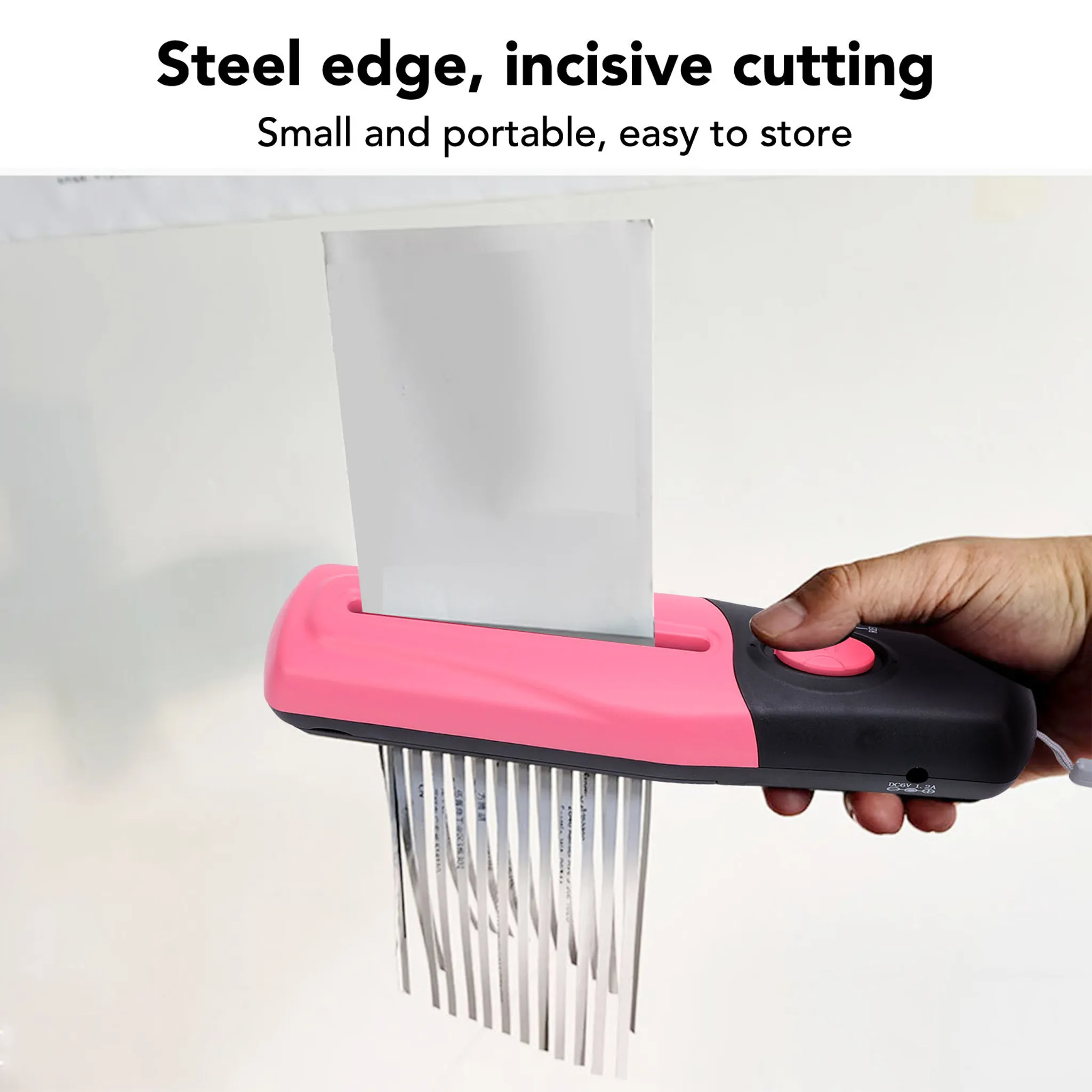 Ein pinker Aktenvernichter zerkleinert Papier in Streifen.